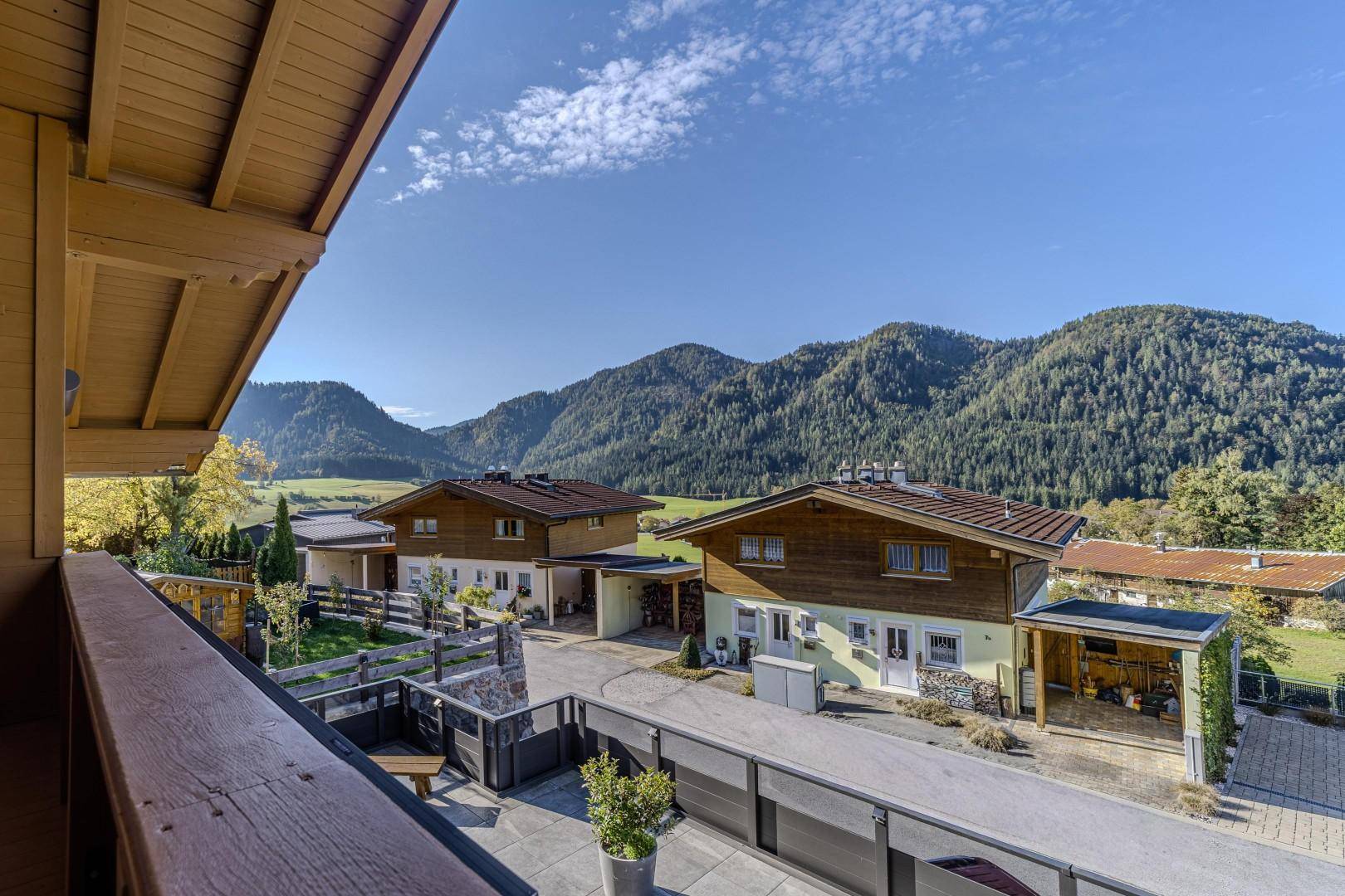 Panoramablick vom Balkon über grüne Hügel, Wälder und die umliegende Wohnbebauung.