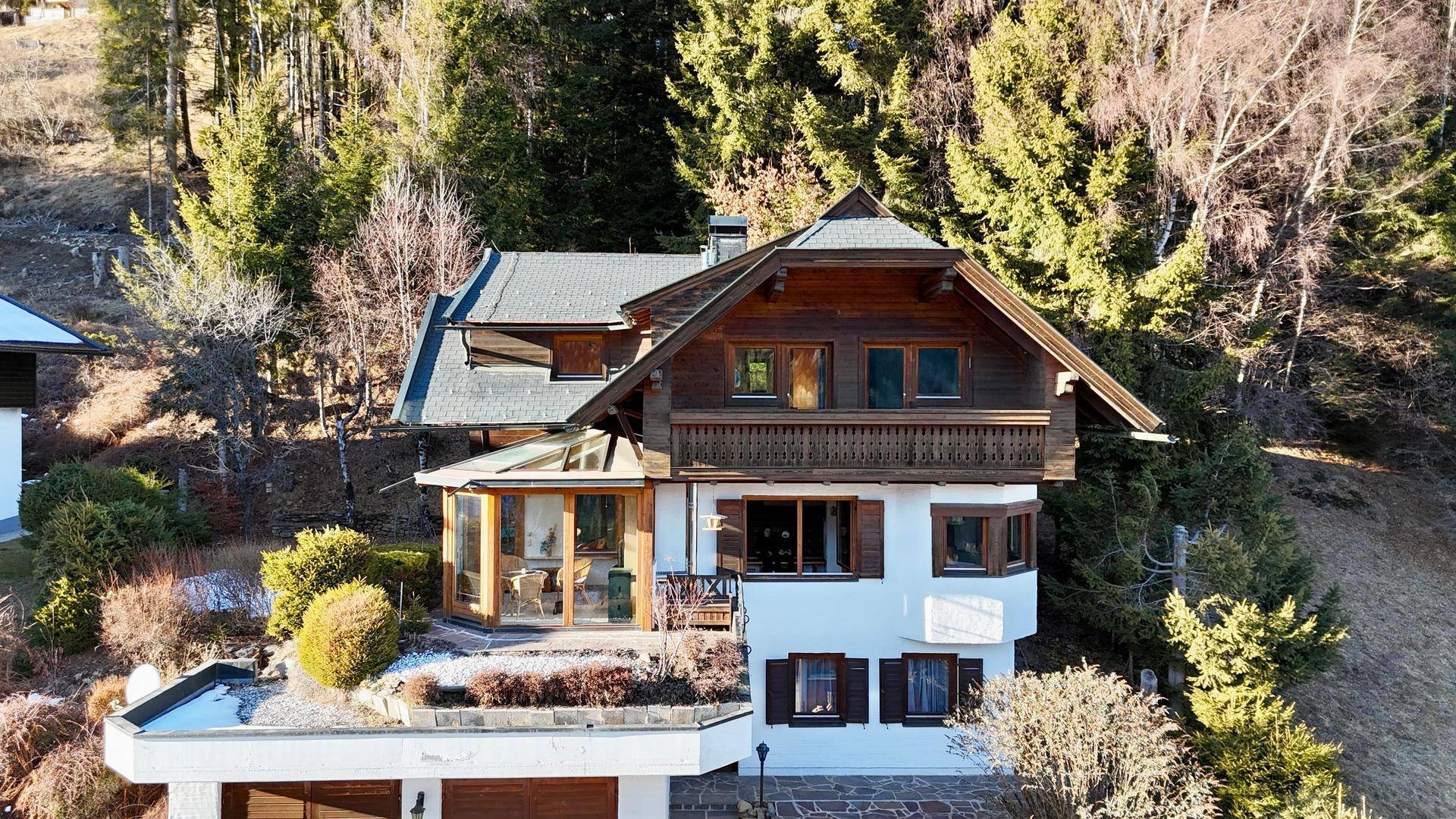 Vorderansicht des traditionellen Chalets mit Holzbalkonen und großen Fenstern.