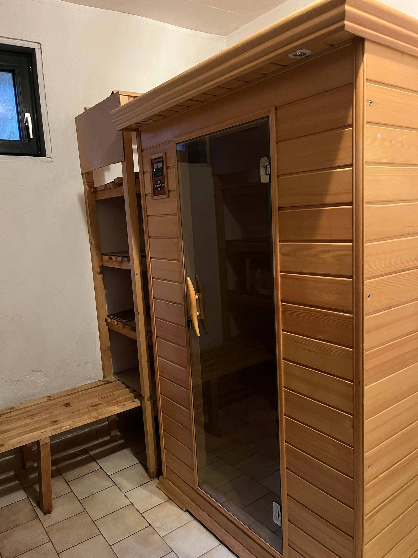 Moderne Saunakabine aus hellem Holz mit Glasfront, bereit für entspannende Wellnessmomente.