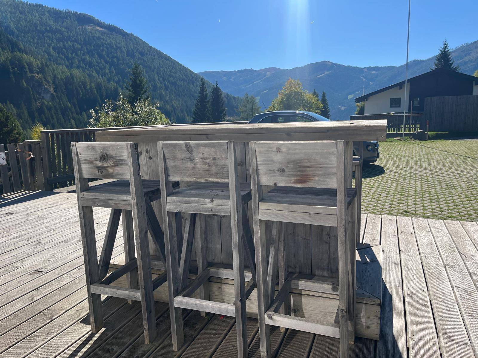 Holzbar mit Hockern auf der Terrasse, ideal für gesellige Abende mit Bergblick.