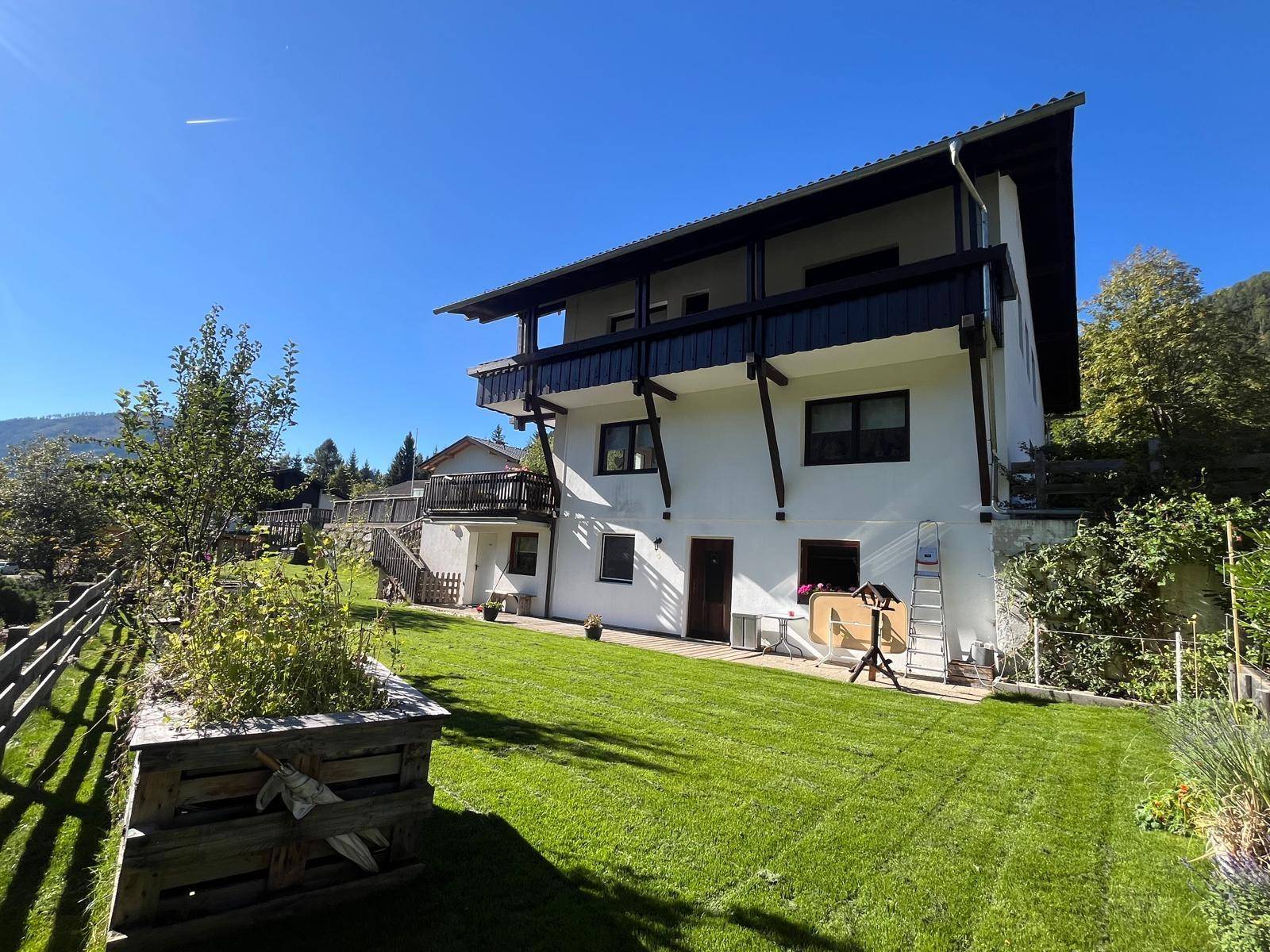 Weitläufiger Gartenbereich mit grünem Rasen und Blick auf die Rückseite des Hauses.