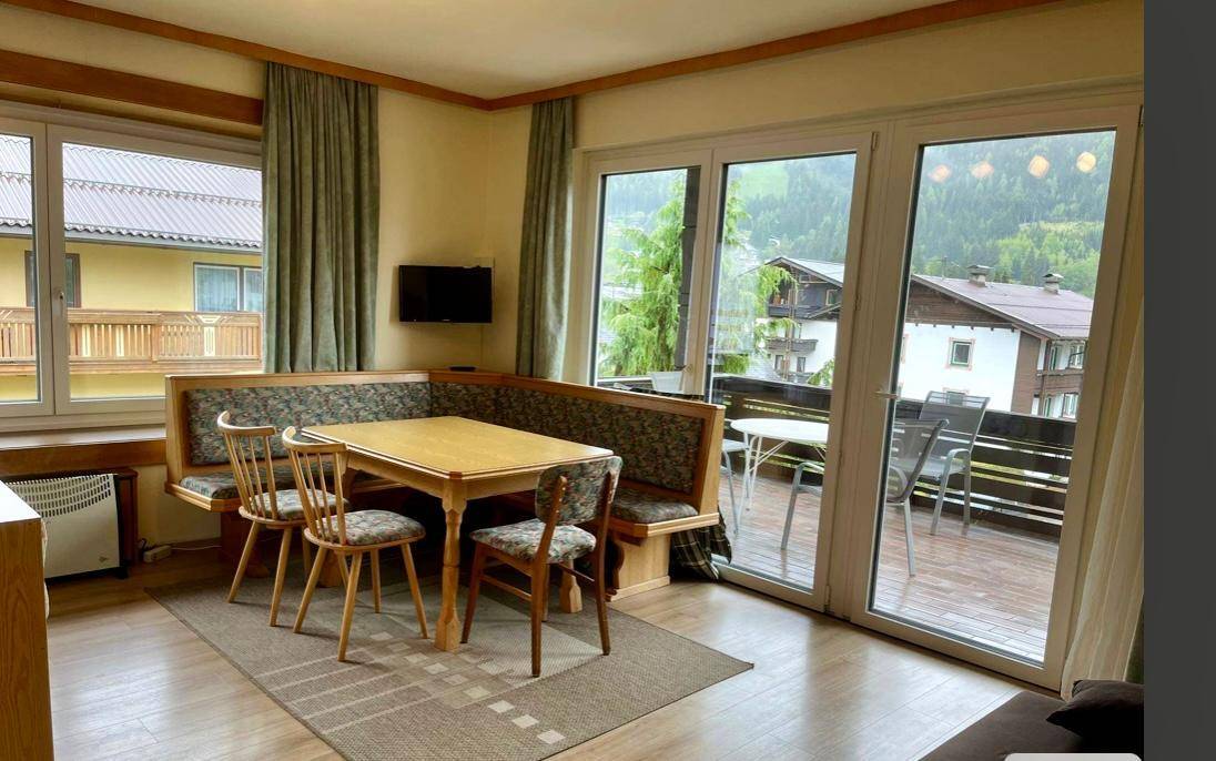 Heller Wohn-Essbereich mit großen Fenstern, Eckbank und direktem Zugang zum Balkon mit Aussicht.