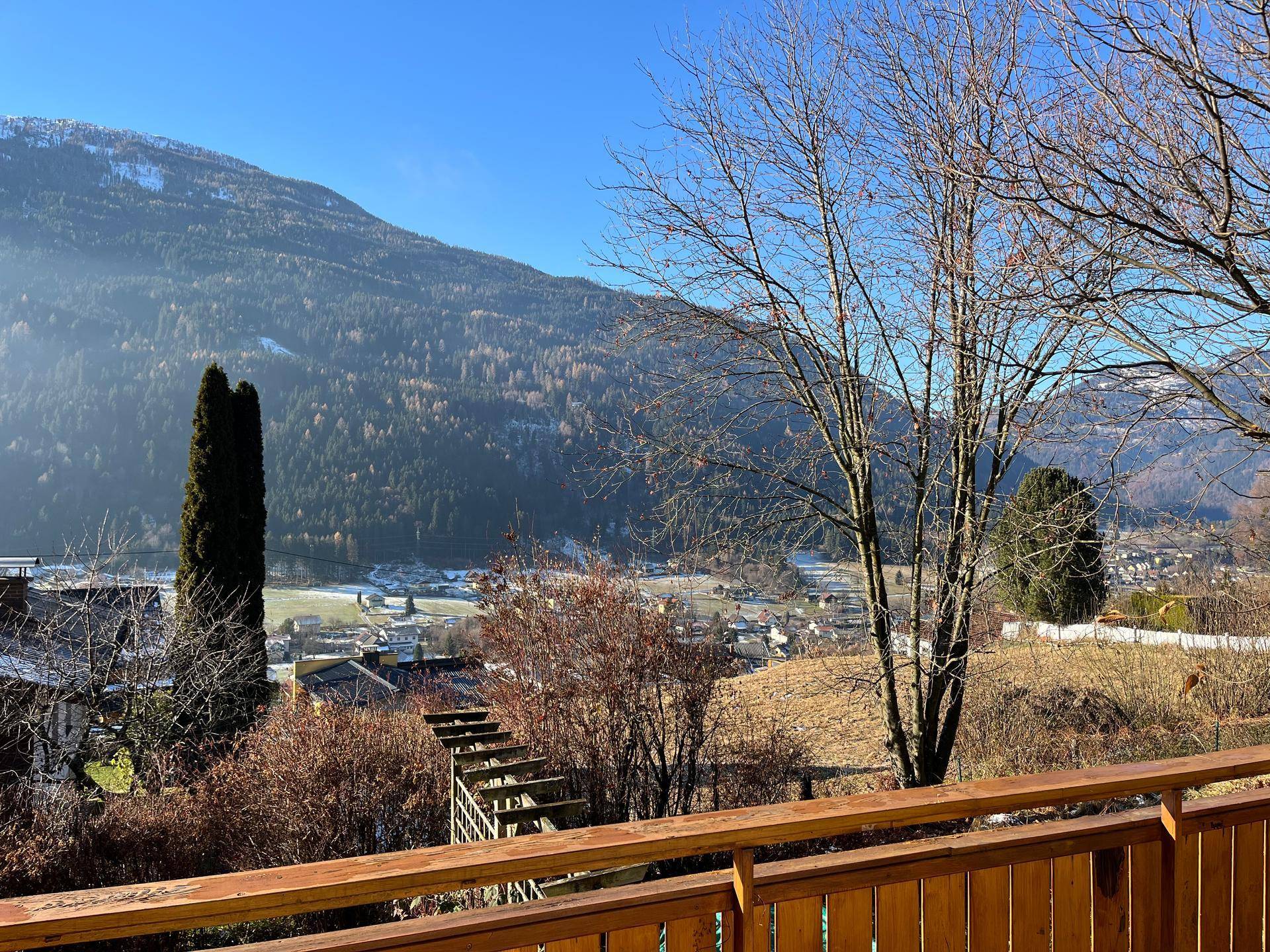 Weitläufiger Ausblick von einem Balkon auf die umliegende Berglandschaft und das Tal.