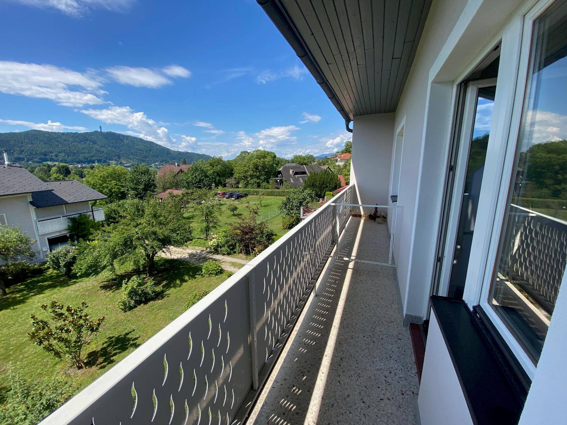 Langer Balkon mit moderner Brüstung und weitem Blick über die grüne Landschaft.