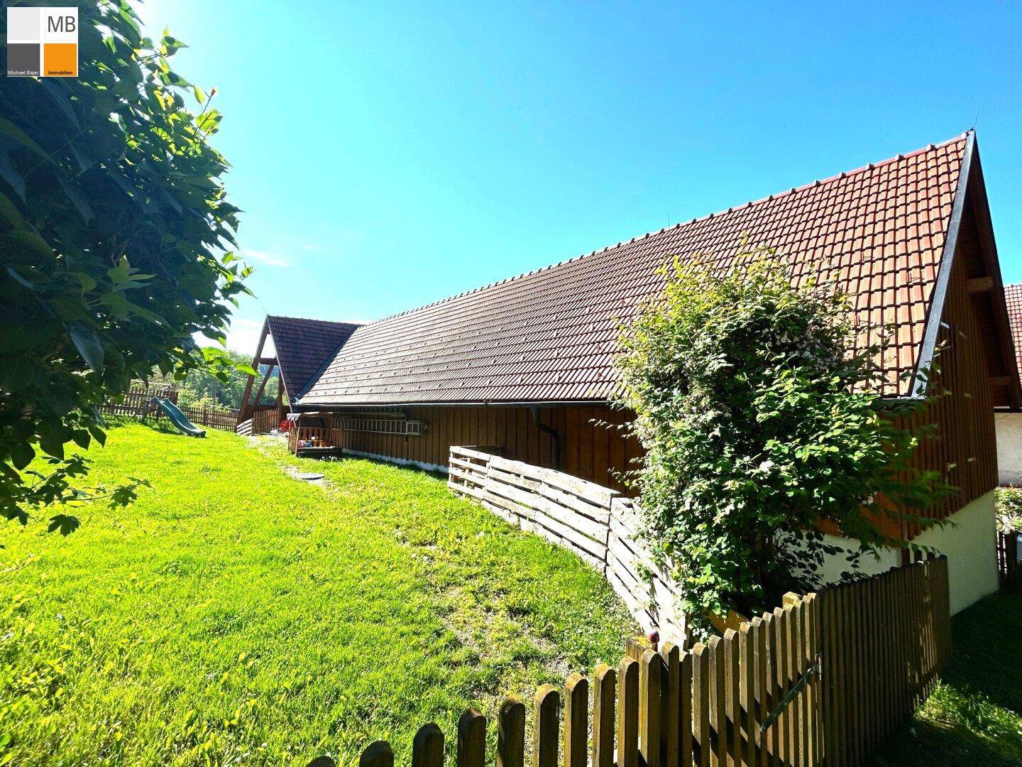 Großer, gepflegter Gartenbereich mit Rasenfläche und Blick auf die Gebäudefassade.