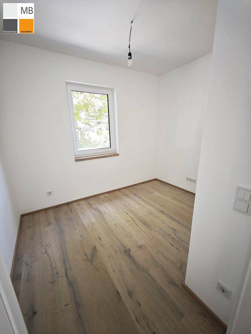 Kleines, helles Zimmer mit Holzdielenboden und einem Fenster, ideal als Schlaf- oder Arbeitszimmer.