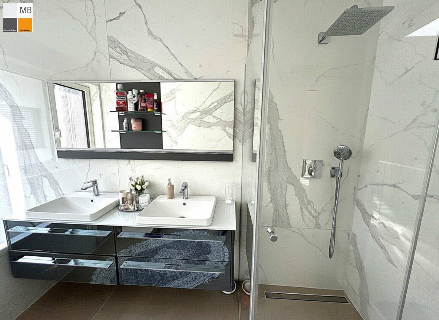Modernes Badezimmer mit Doppelwaschbecken, begehbarer Dusche und eleganten Marmorfliesen.