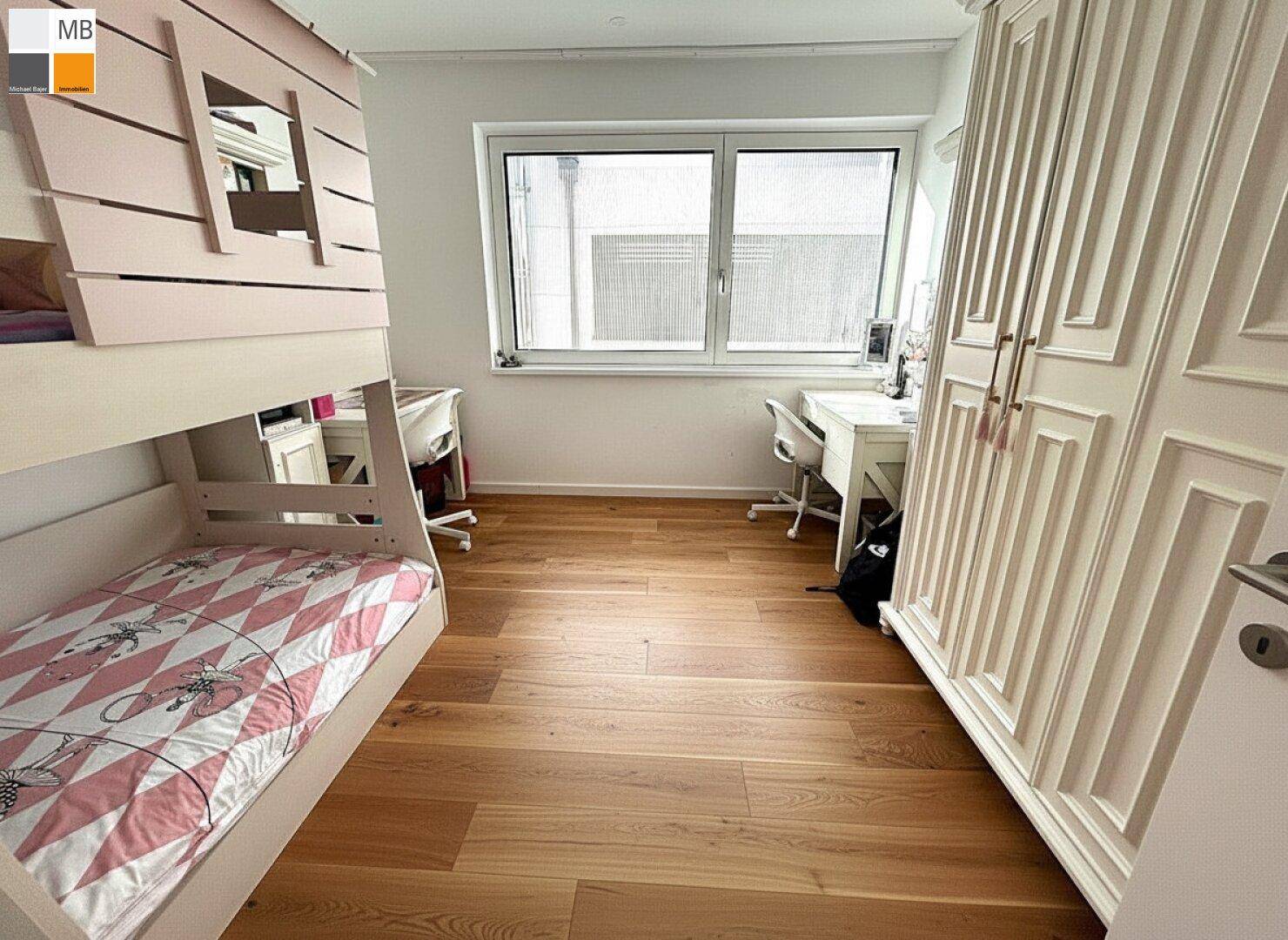 Helles Kinderzimmer mit Etagenbett, Holzboden und weißem Kleiderschrank.