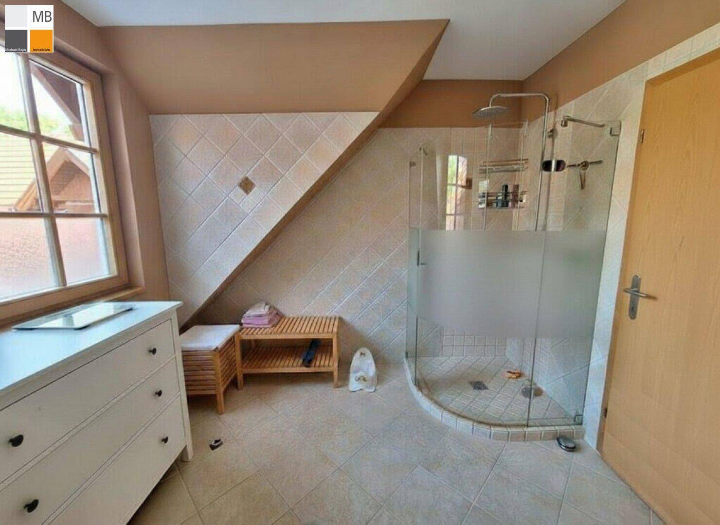 Modernes Badezimmer mit begehbarer Dusche, Fenster und Fliesenboden unter der Dachschräge.