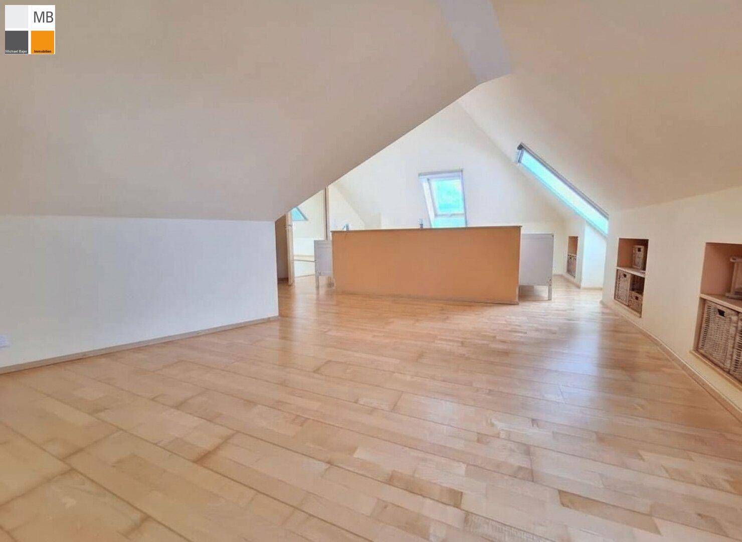 Geräumiger Dachboden mit Holzboden und Dachfenstern, ideal als zusätzlicher Wohnraum.