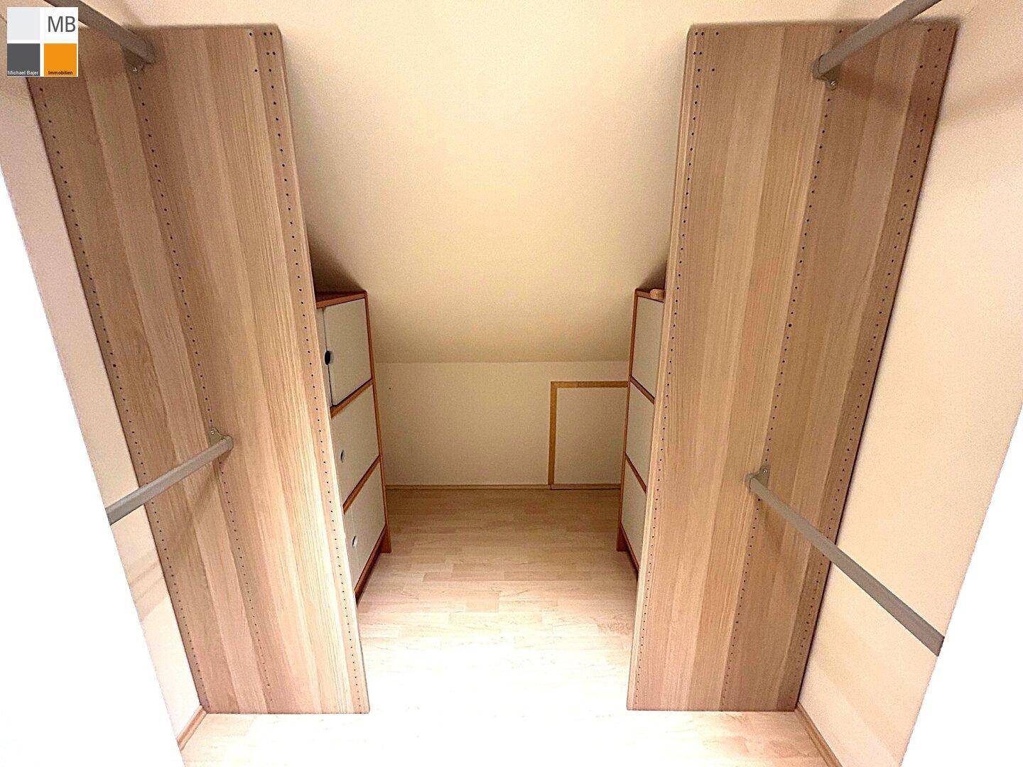 Praktischer begehbarer Kleiderschrank im Dachgeschoss mit viel Stauraum und Schrägen.