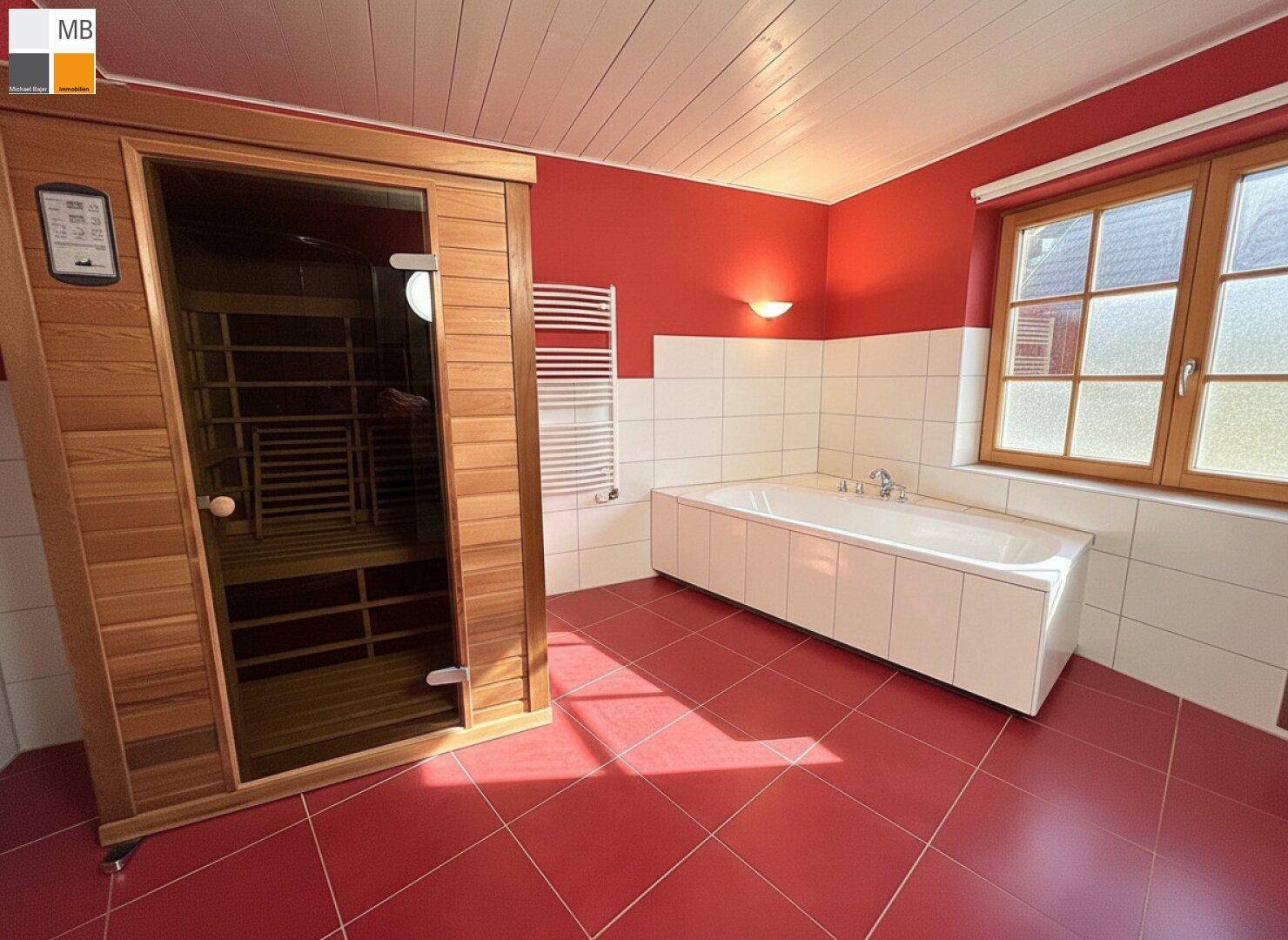 Großes Badezimmer mit integrierter Sauna, Badewanne und roten Bodenfliesen.