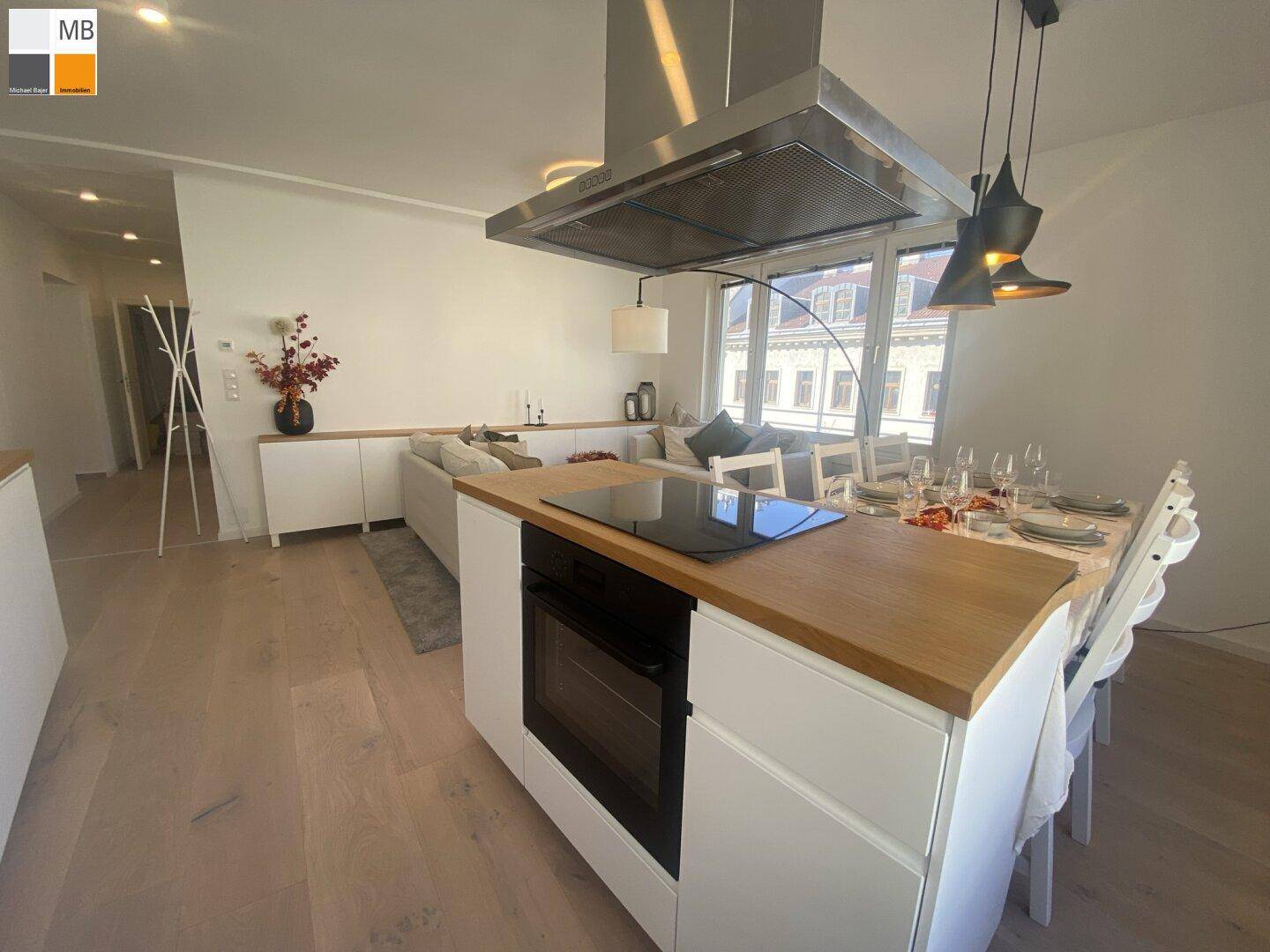 Moderne Kücheninsel mit Kochfeld und Backofen im offenen Wohn- und Essbereich.