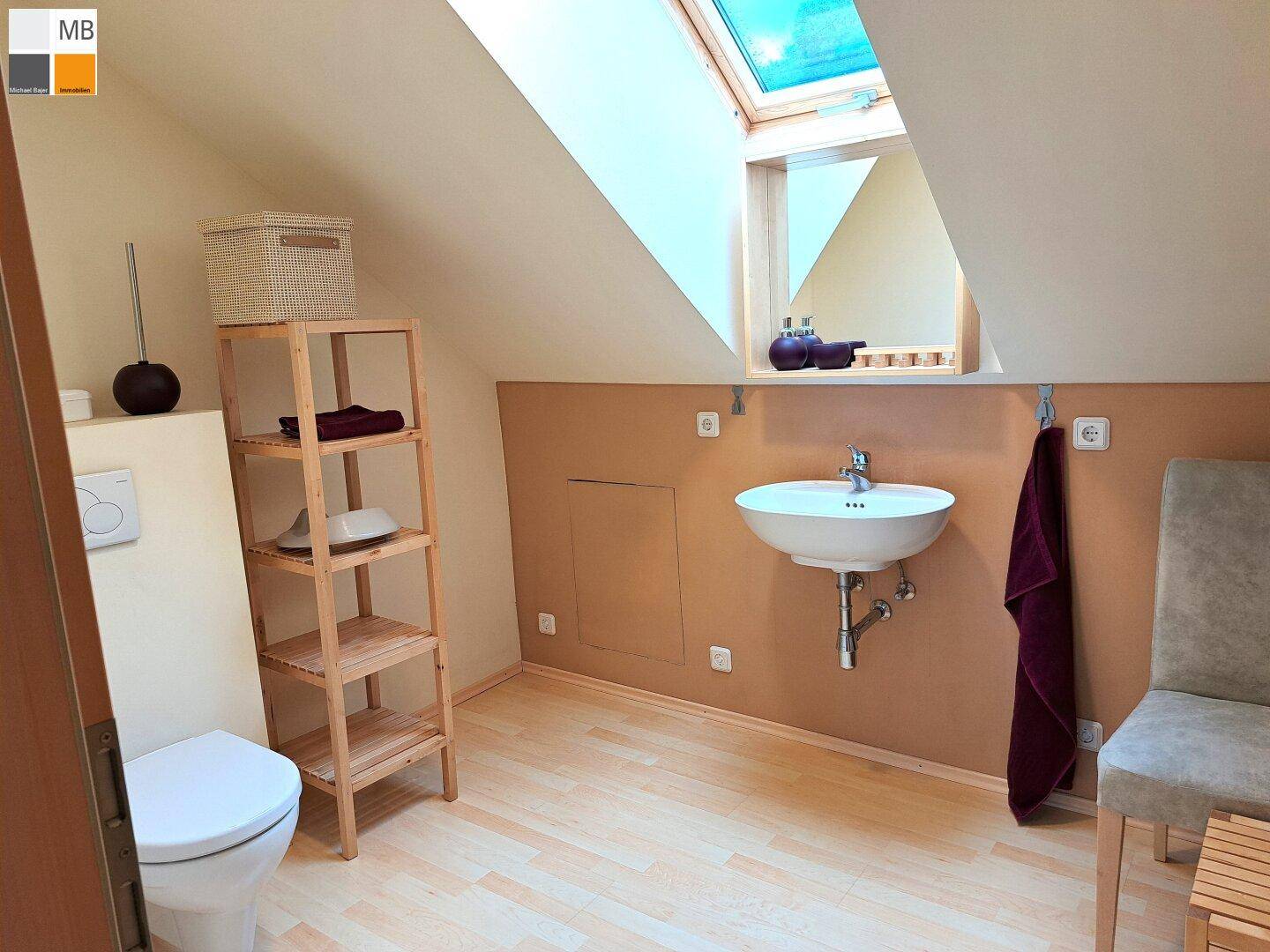 Modernes Badezimmer mit Dachschräge, Dachfenster, WC und Einzelwaschbecken.