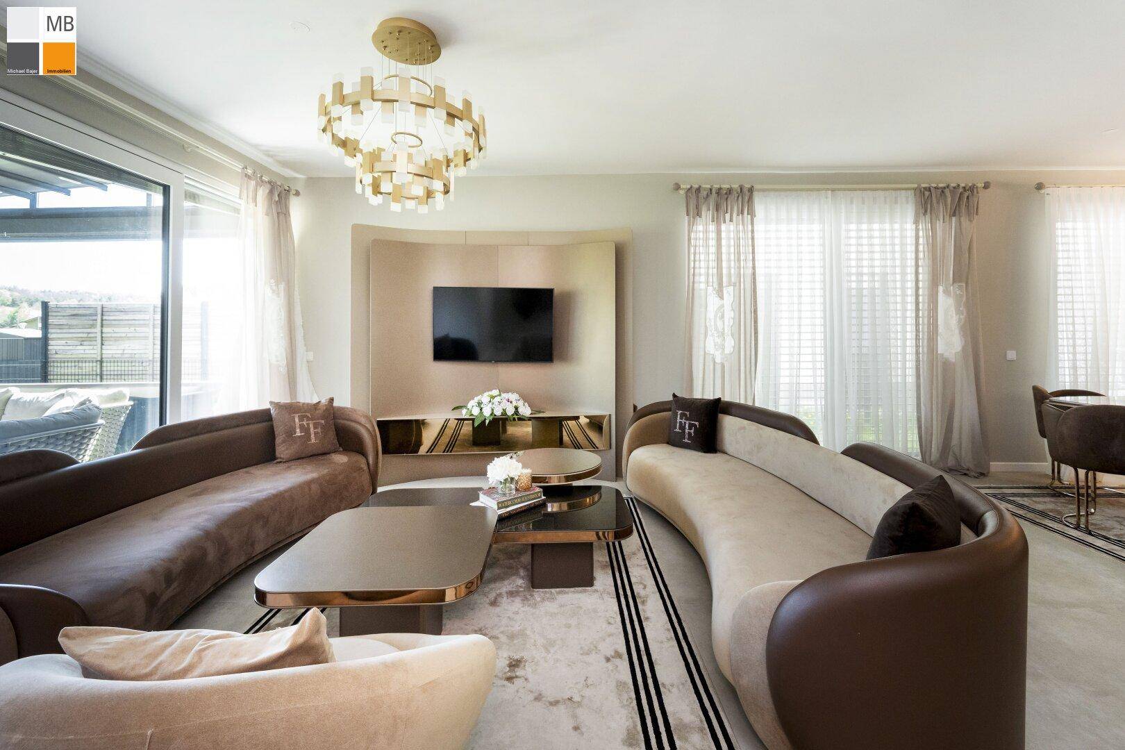 Luxuriöses Wohnzimmer mit eleganten Sofas, stilvoller Dekoration und großzügigen Fenstern.