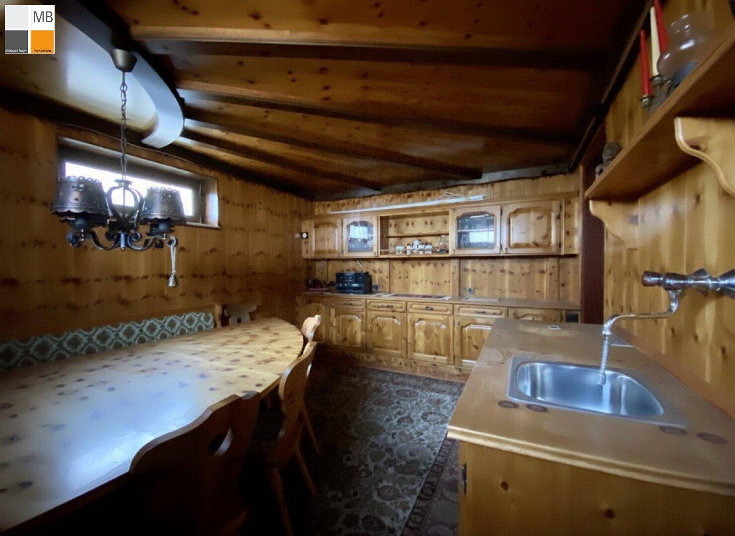 Rustikale Holzküche mit Essbereich, Holzvertäfelung und traditionellem Charme.