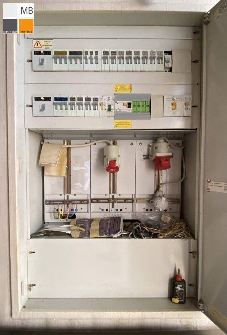 Elektrischer Sicherungskasten mit verschiedenen Schaltern und Verkabelungen für die Stromversorgung.