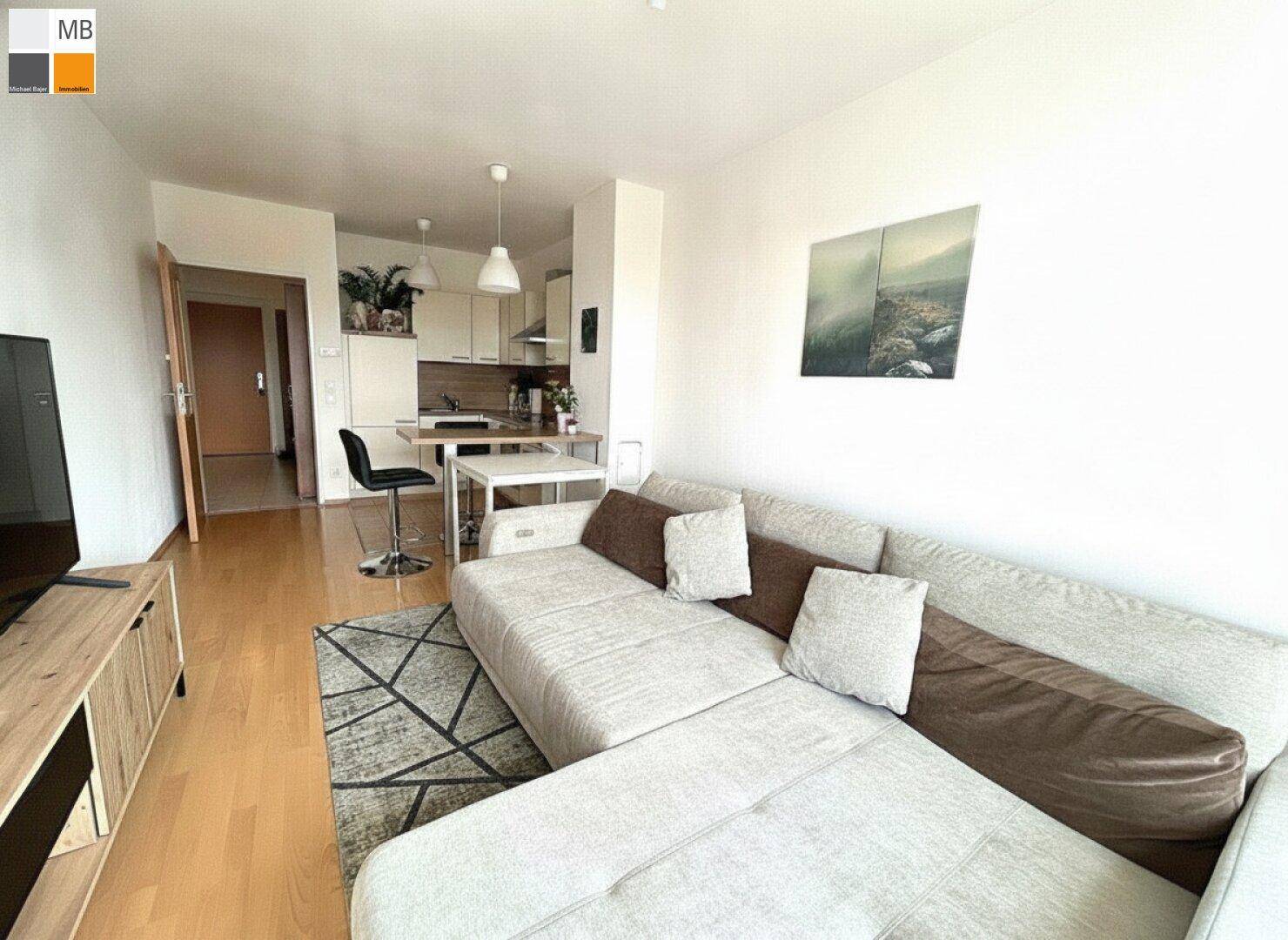 Gemütlicher Wohnbereich mit großem Ecksofa und Blick auf die offene Küche.