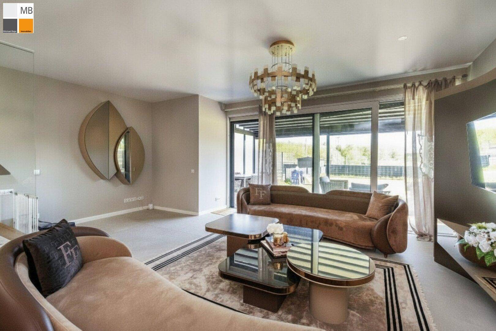 Gemütliches Wohnzimmer mit stilvollen Sofas, modernen Tischen und Zugang zur Terrasse.