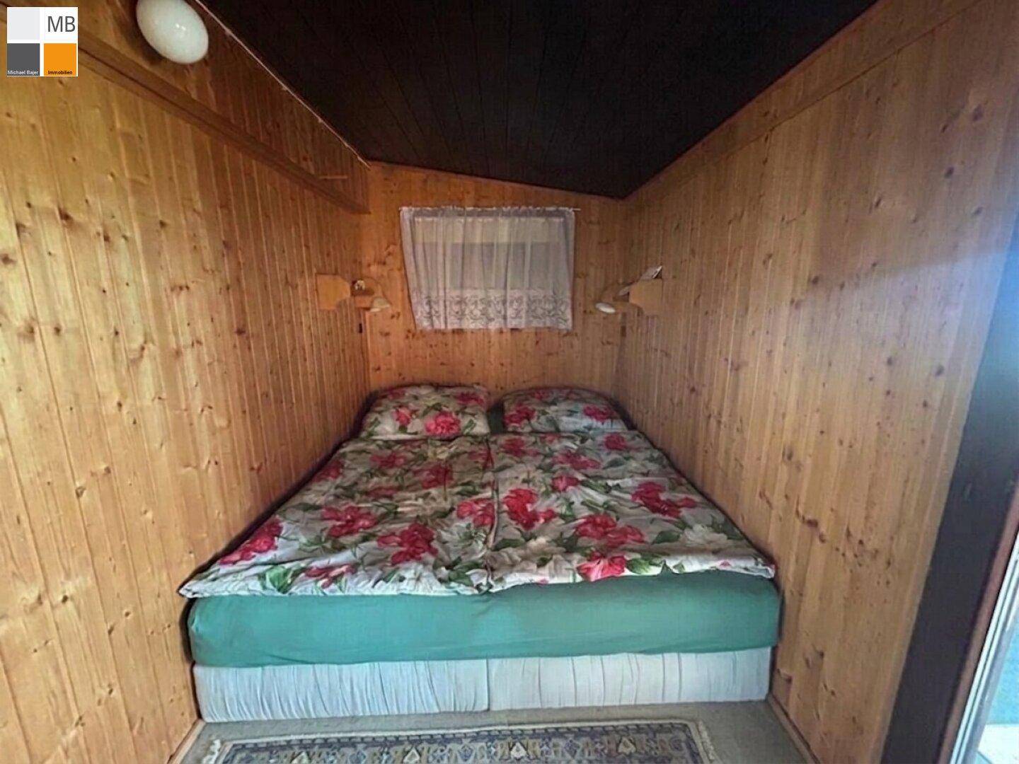 Gemütliches Schlafzimmer mit Doppelbett und Holzvertäfelung, ideal für eine ruhige Nacht.