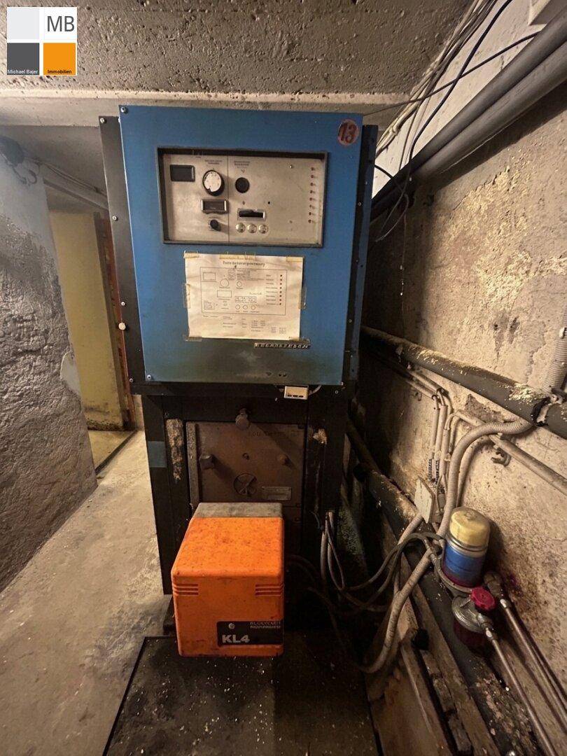 Heizungsanlage im Keller mit Steuerungseinheit und verschiedenen Anschlüssen.