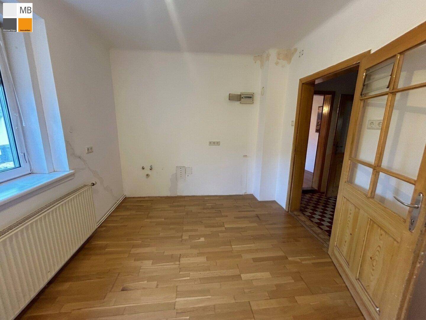 Schlafzimmer mit Parkettboden und Holztür, bereit für individuelle Gestaltung.
