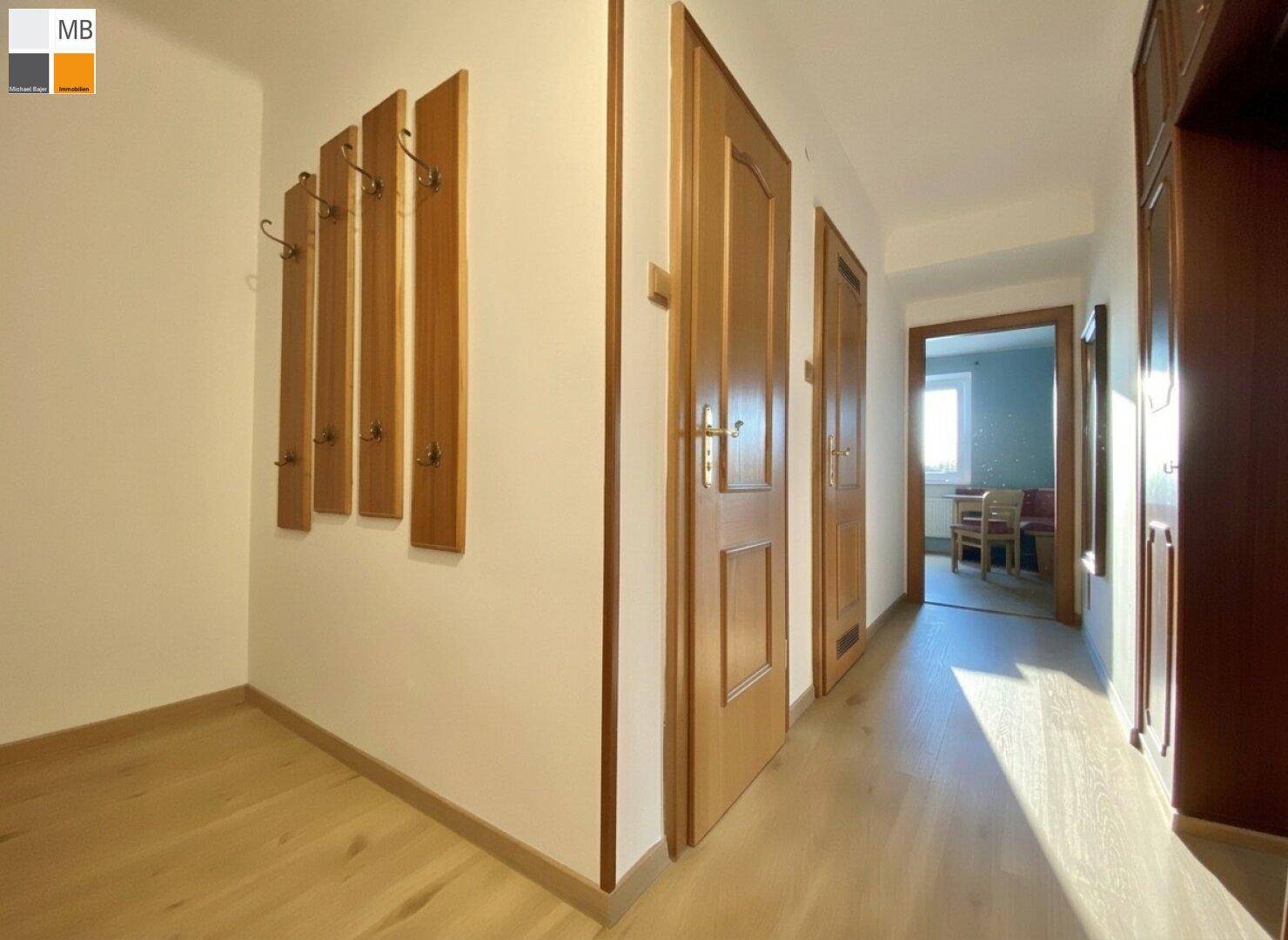 Geräumiger Flur mit Holzboden und Garderobenpaneelen, der einen einladenden Eingangsbereich schafft.