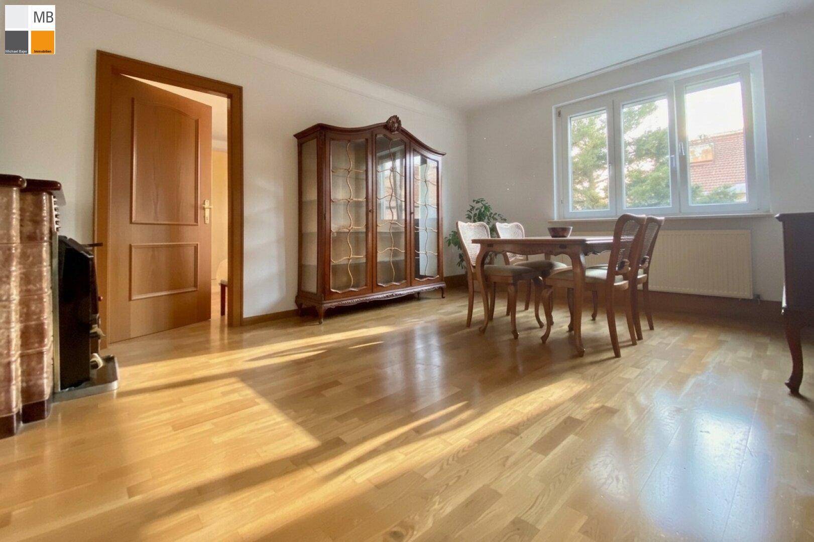 Klassischer Essbereich mit Holzboden, großem Fenster und antiker Vitrine, ideal für Familienessen.