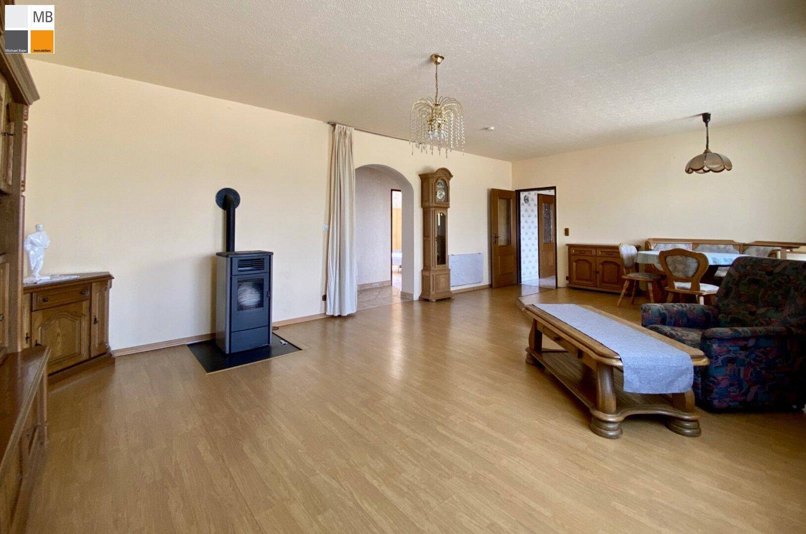 Gemütliches Wohnzimmer mit Holzofen, Parkettboden und traditionellen Möbeln.