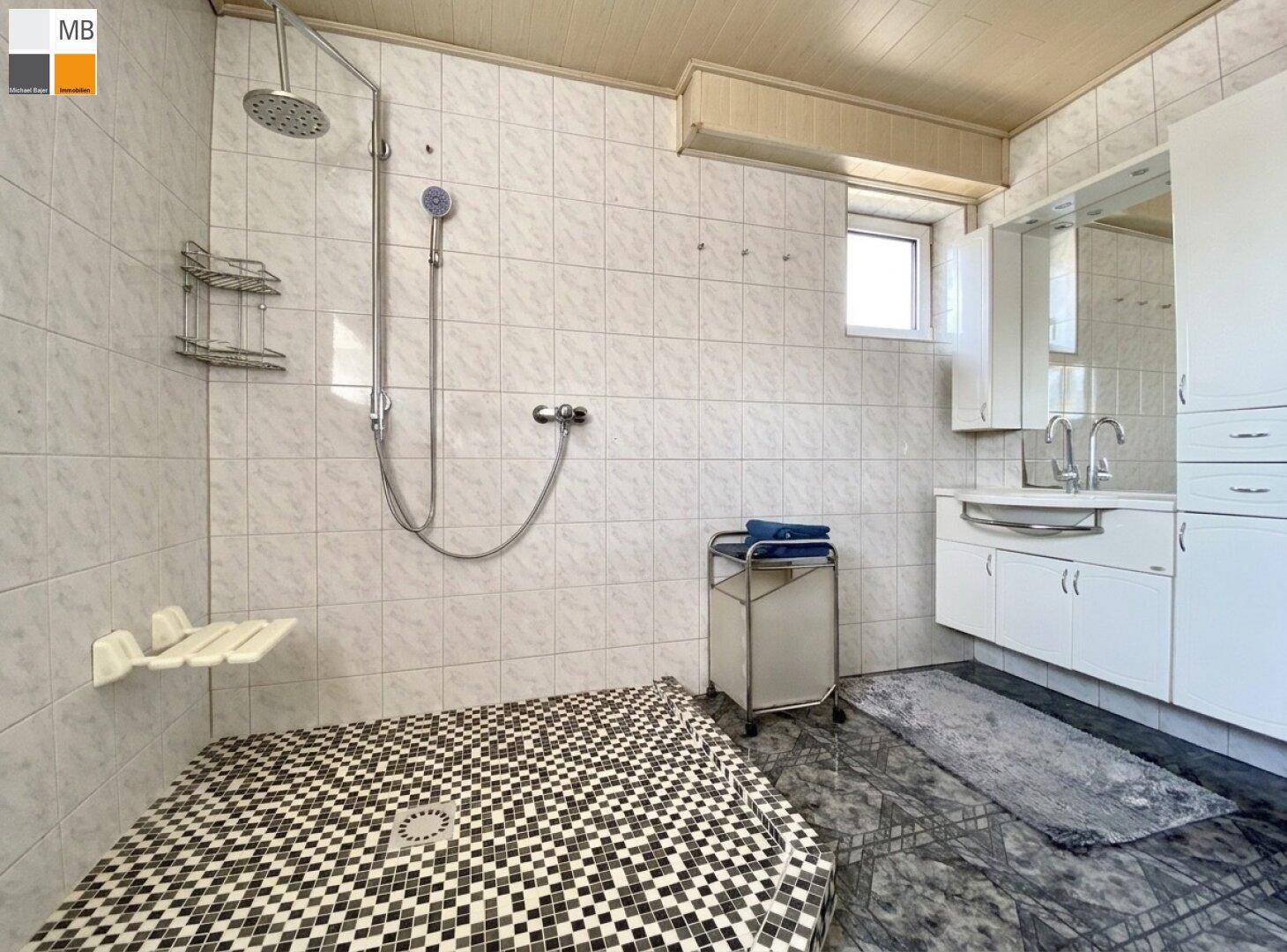 Helles Badezimmer mit Duschbereich, Doppelwaschbecken und weißen Fliesen.
