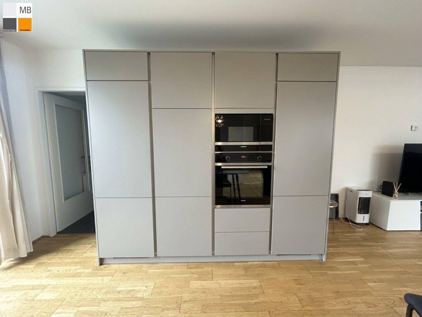 Hoher Küchenschrank mit integriertem Backofen und Mikrowelle in modernem Design.