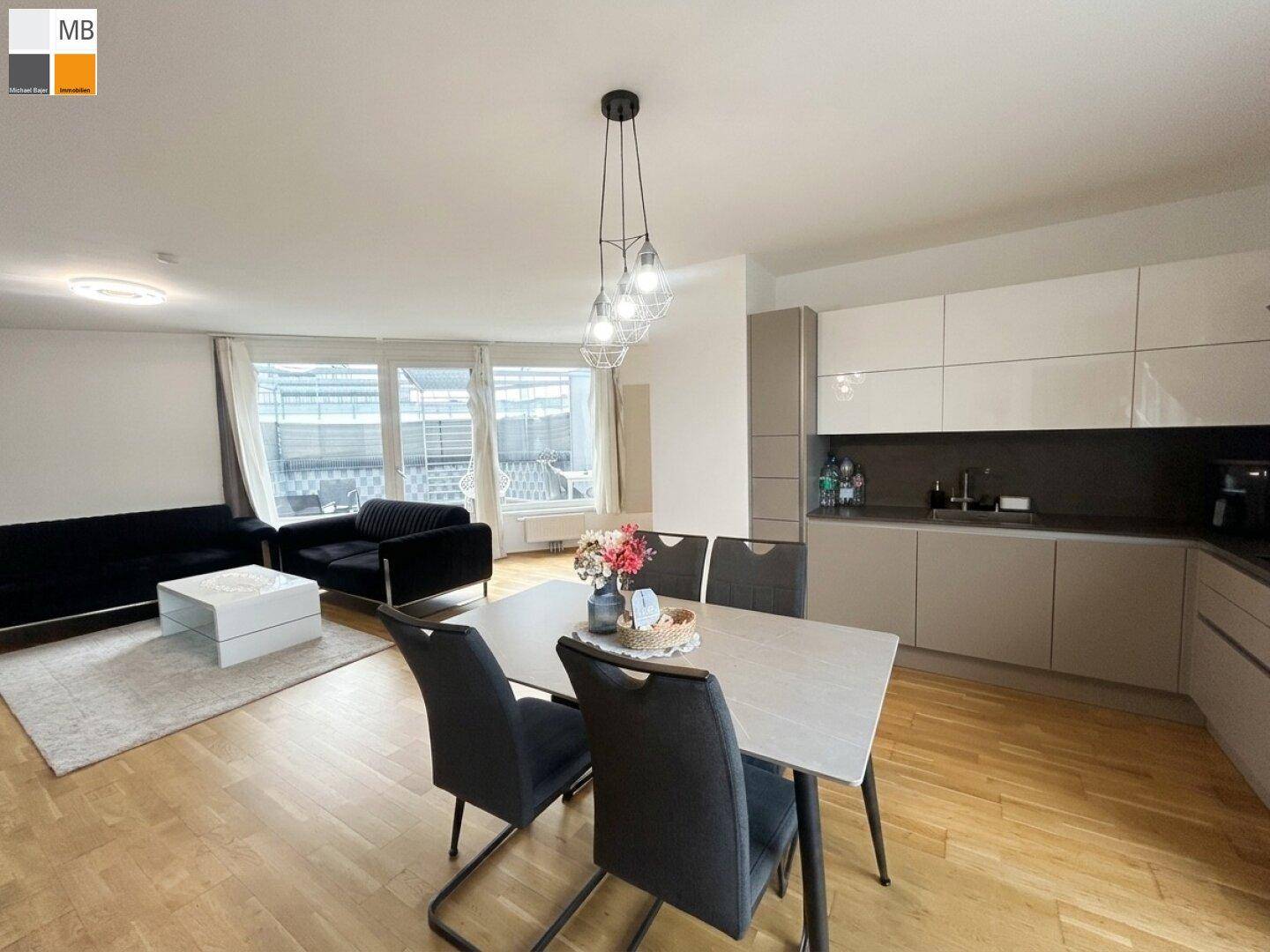 Moderner Wohn-Essbereich mit offener Küche, Esstisch und Zugang zur Dachterrasse.