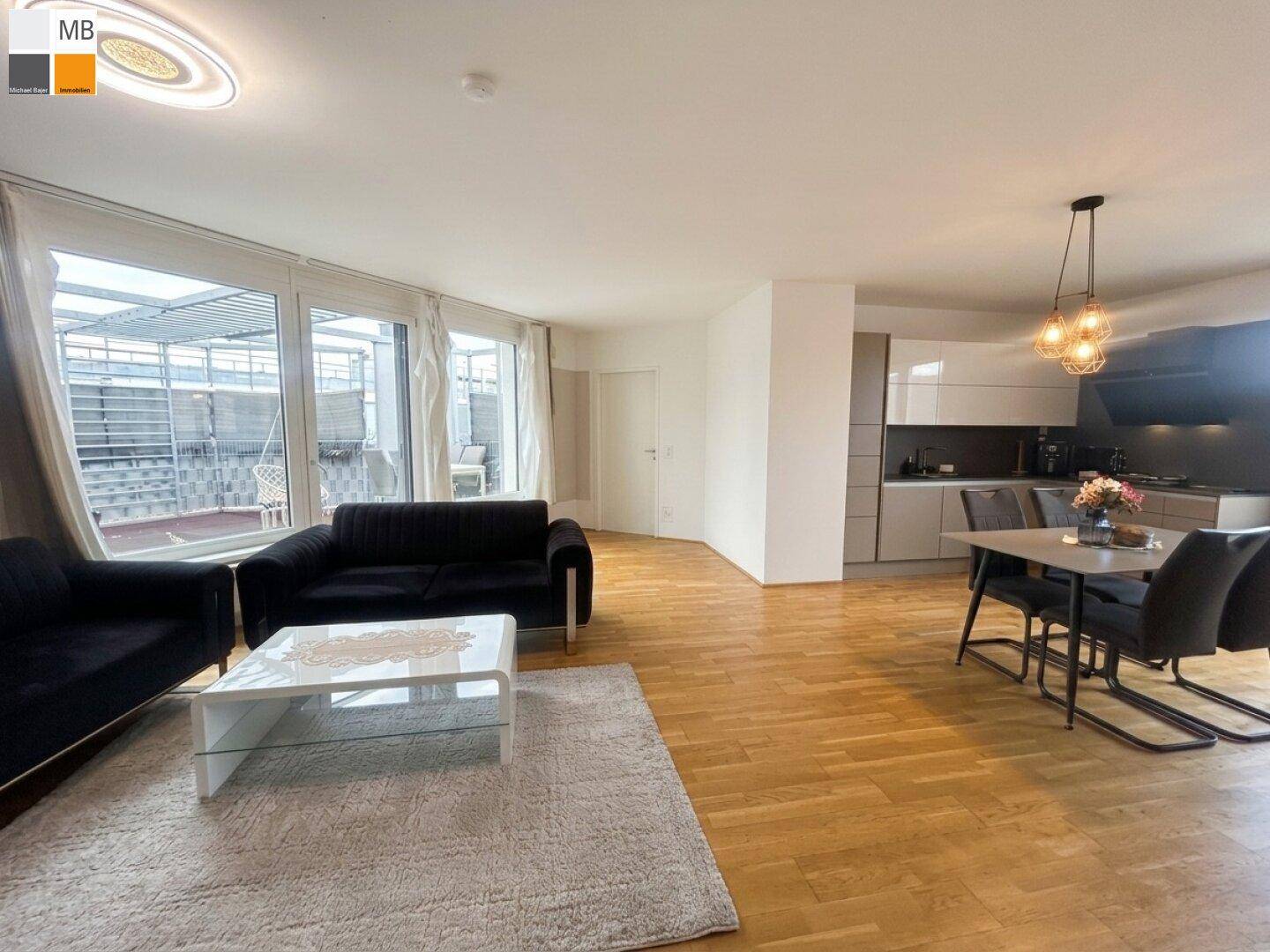 Offener Wohn-Essbereich mit integrierter Küche, Parkettboden und Zugang zur Dachterrasse.