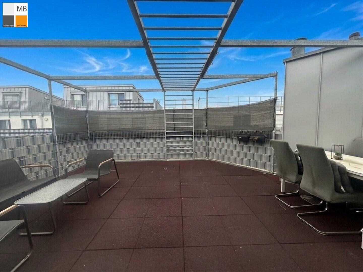 Weitläufige Dachterrasse mit Metallkonstruktion, Sitzgelegenheiten und Blick auf die umliegenden Gebäude.