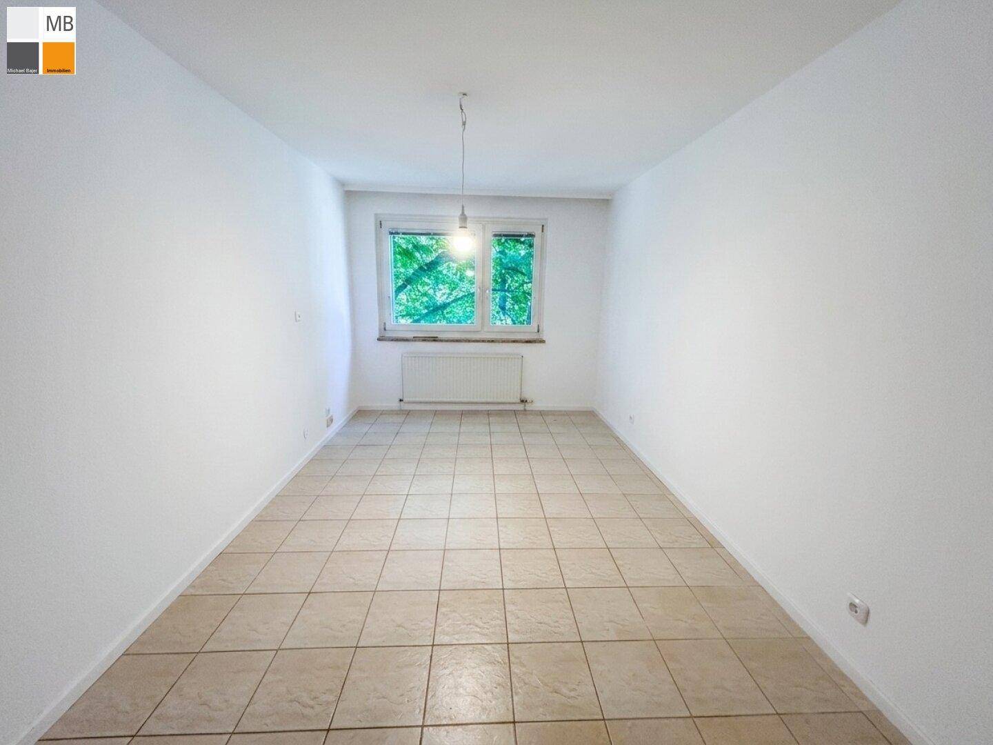 Heller, leerer Raum mit beigen Fliesen und weißen Wänden, ideal als Wohn- oder Schlafzimmer.