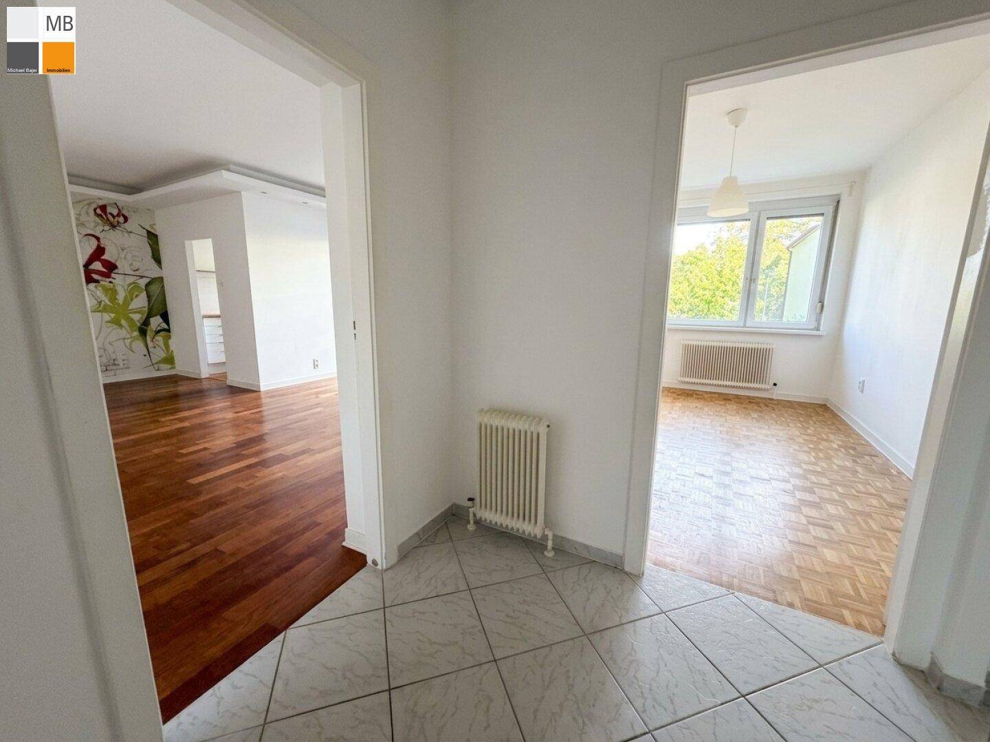 Heller Flur mit Fliesenboden und Zugang zu Wohnzimmer und Schlafzimmer.