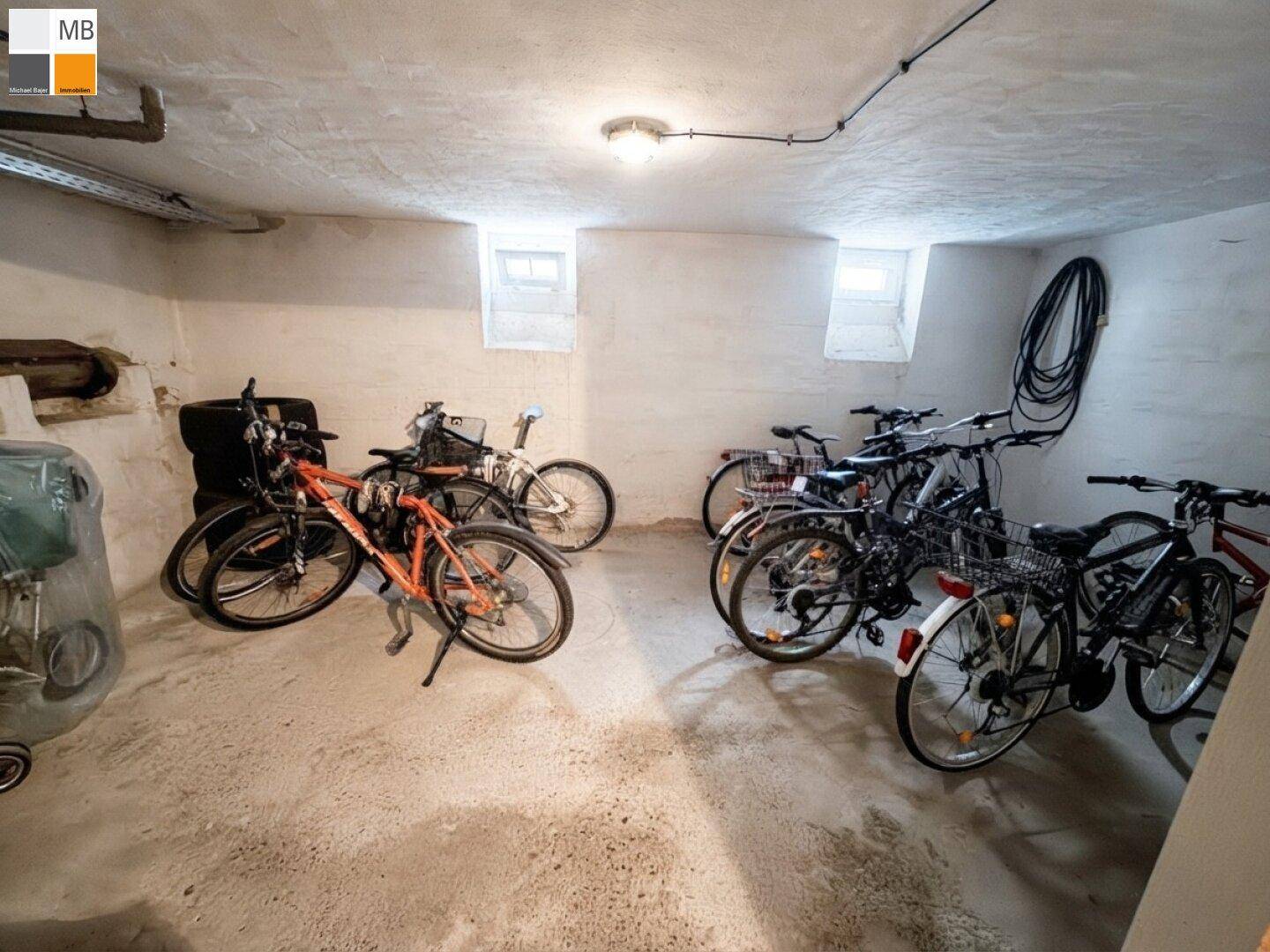 Fahrradraum im Keller mit mehreren Fahrrädern und kleinen Fenstern für Belüftung.