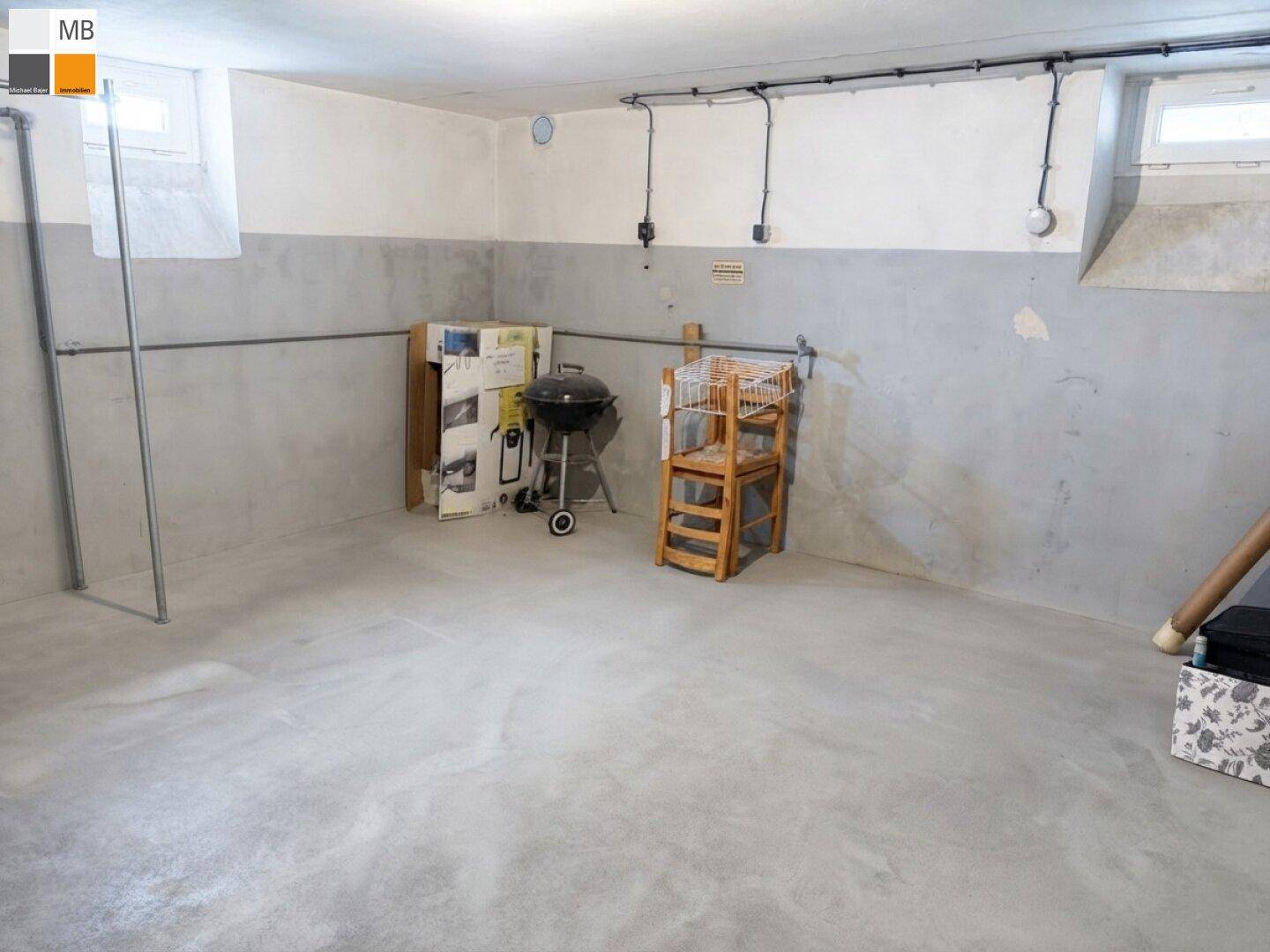 Geräumiger Kellerraum mit Betonboden und weiß-grau gestrichenen Wänden, vielseitig nutzbar.