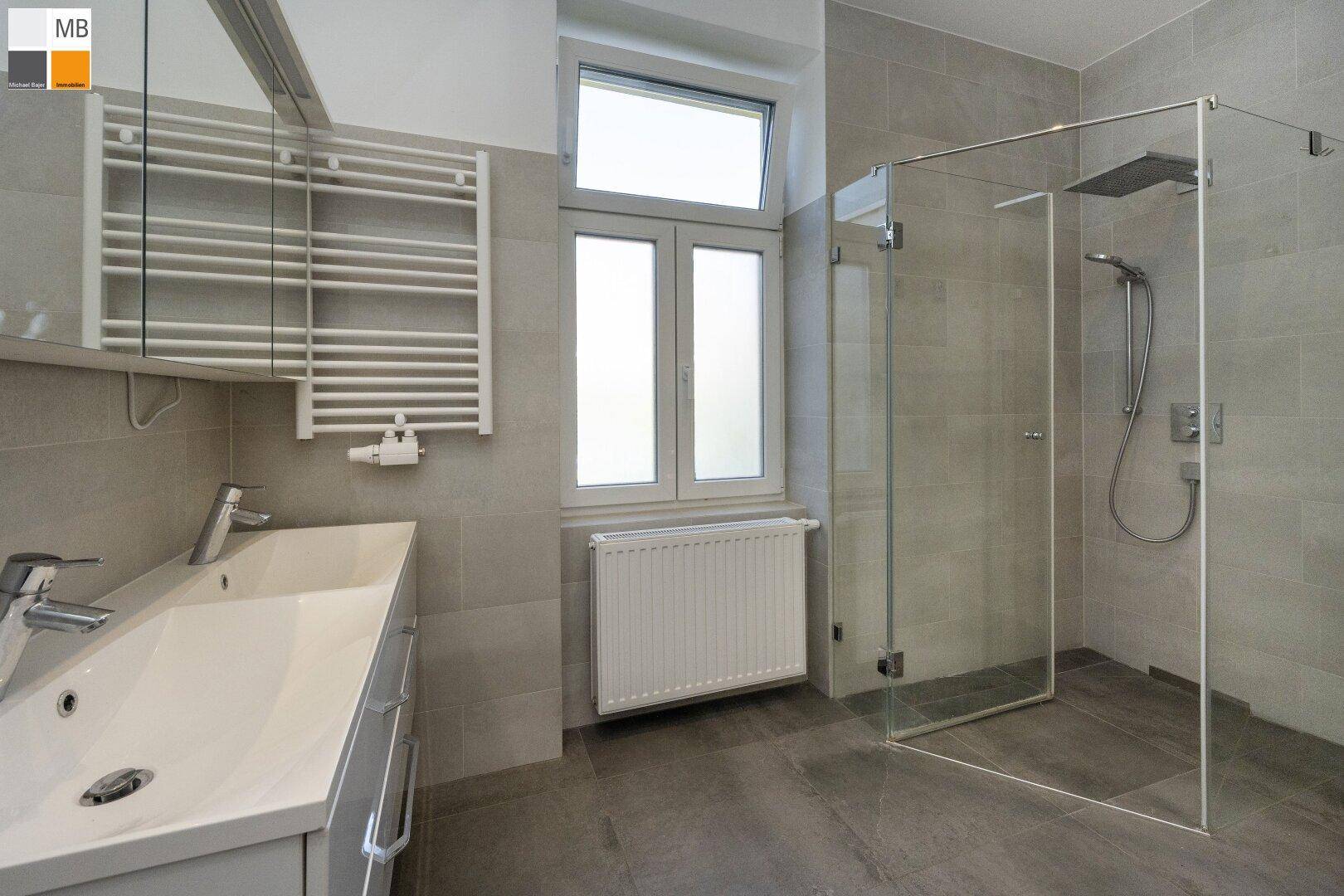 Modernes Badezimmer mit ebenerdiger Dusche, großformatigen Fliesen und Fenster.
