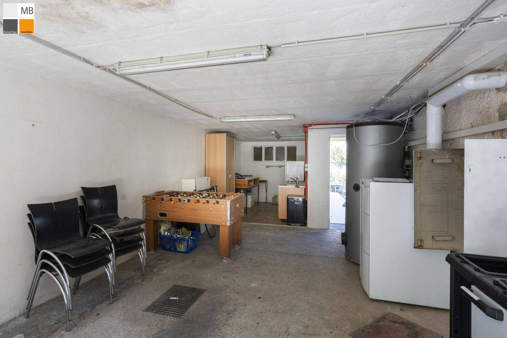 Vielseitiger Kellerraum mit Tischfußball, Heizungsanlage und Stauraum.