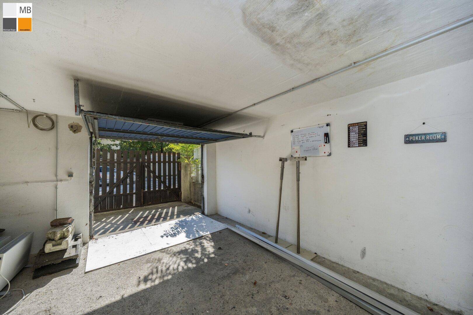 Geräumige Garage mit offenem Tor und direktem Zugang zum Außenbereich.