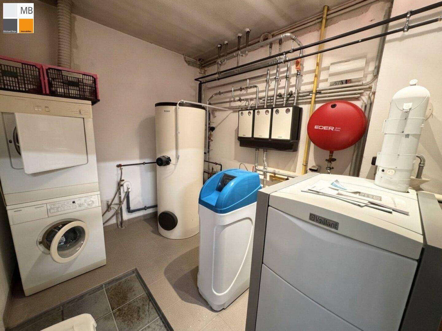 Praktischer Hauswirtschaftsraum im Keller mit Waschmaschine, Trockner und Heizungsanlage.