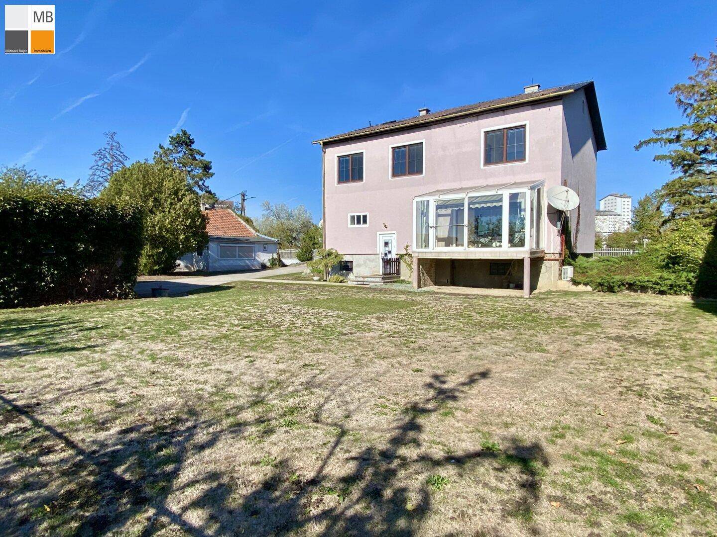 Rückansicht des Hauses mit Wintergarten und weitem Blick über den Garten und die Umgebung.