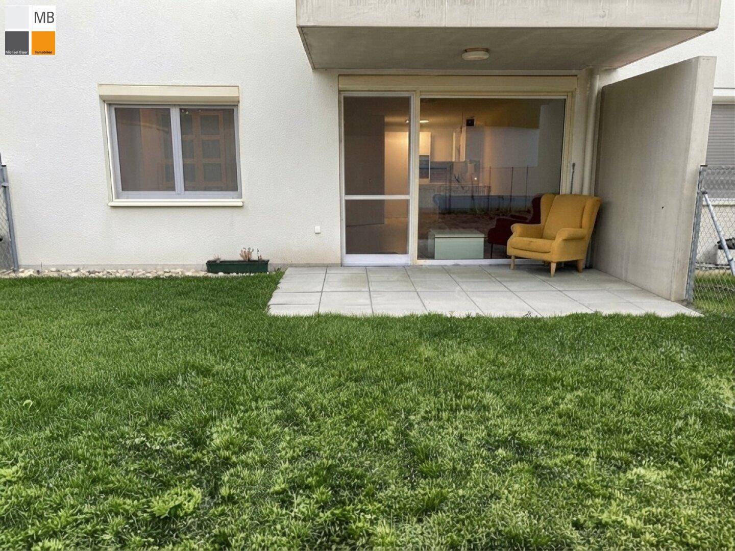 Terrasse mit Zugang zum Garten und Blick auf die grüne Umgebung.