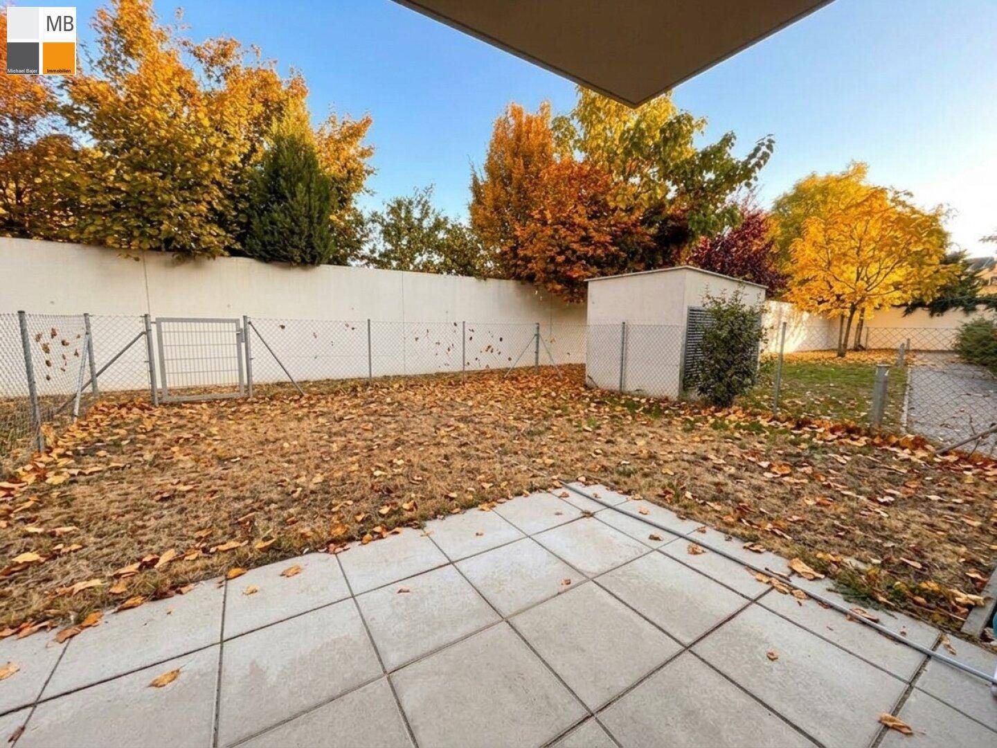 Gartenbereich mit Terrasse und herbstlicher Laubfärbung, ideal für die Freizeitgestaltung.