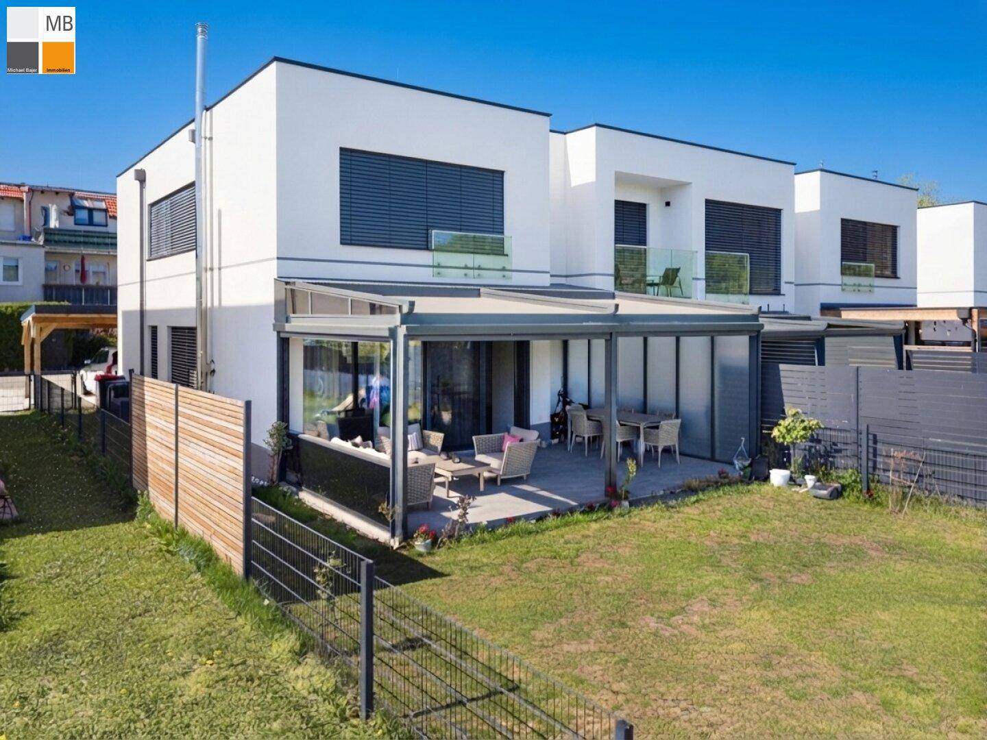 Moderne Doppelhaushälfte mit großem Garten und überdachter Terrasse für entspannte Stunden.