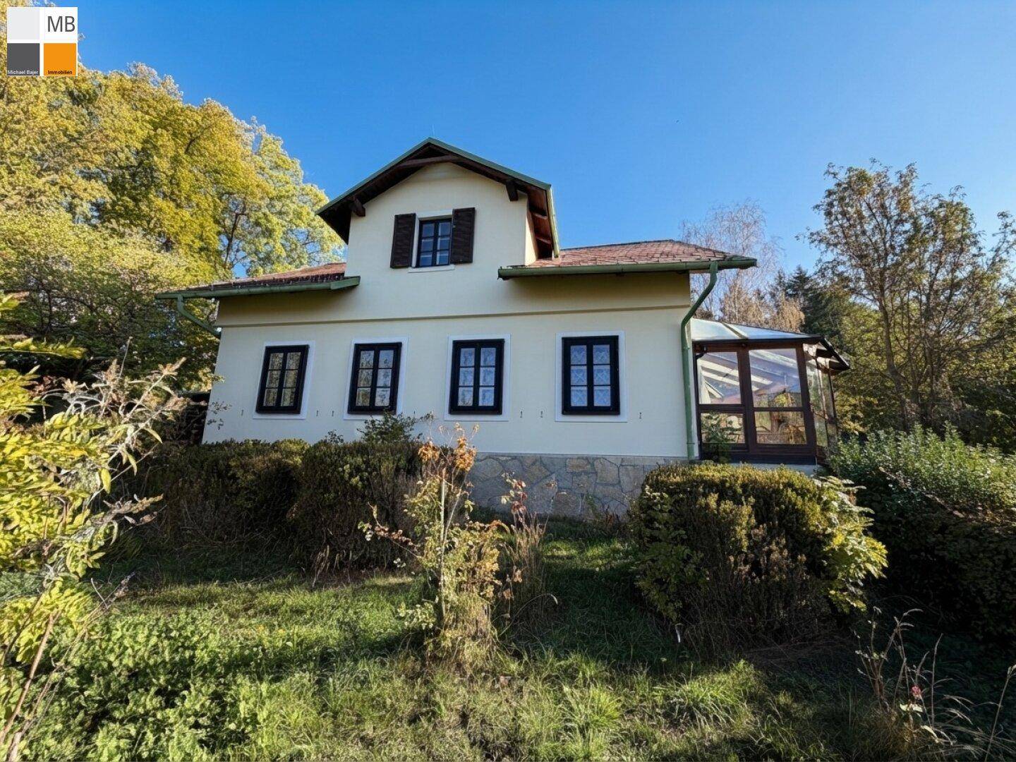 Charmantes Landhaus mit traditioneller Architektur, Sprossenfenstern und einem Wintergartenanbau.