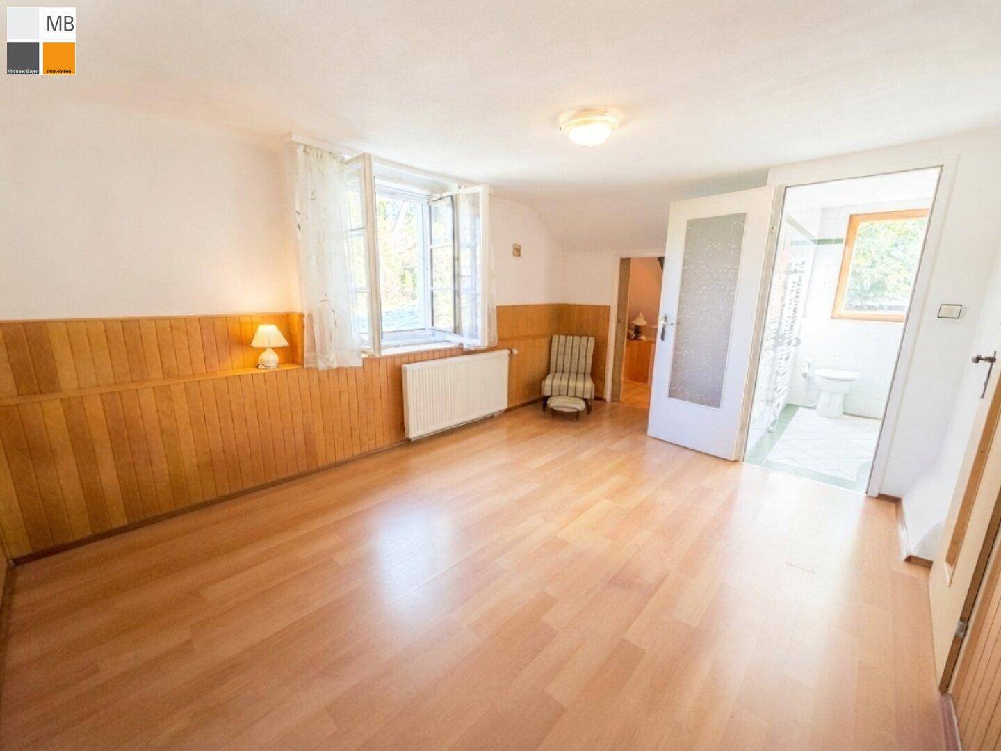Gemütliches Schlafzimmer mit Laminatboden und Fenster, das viel Tageslicht hereinlässt.