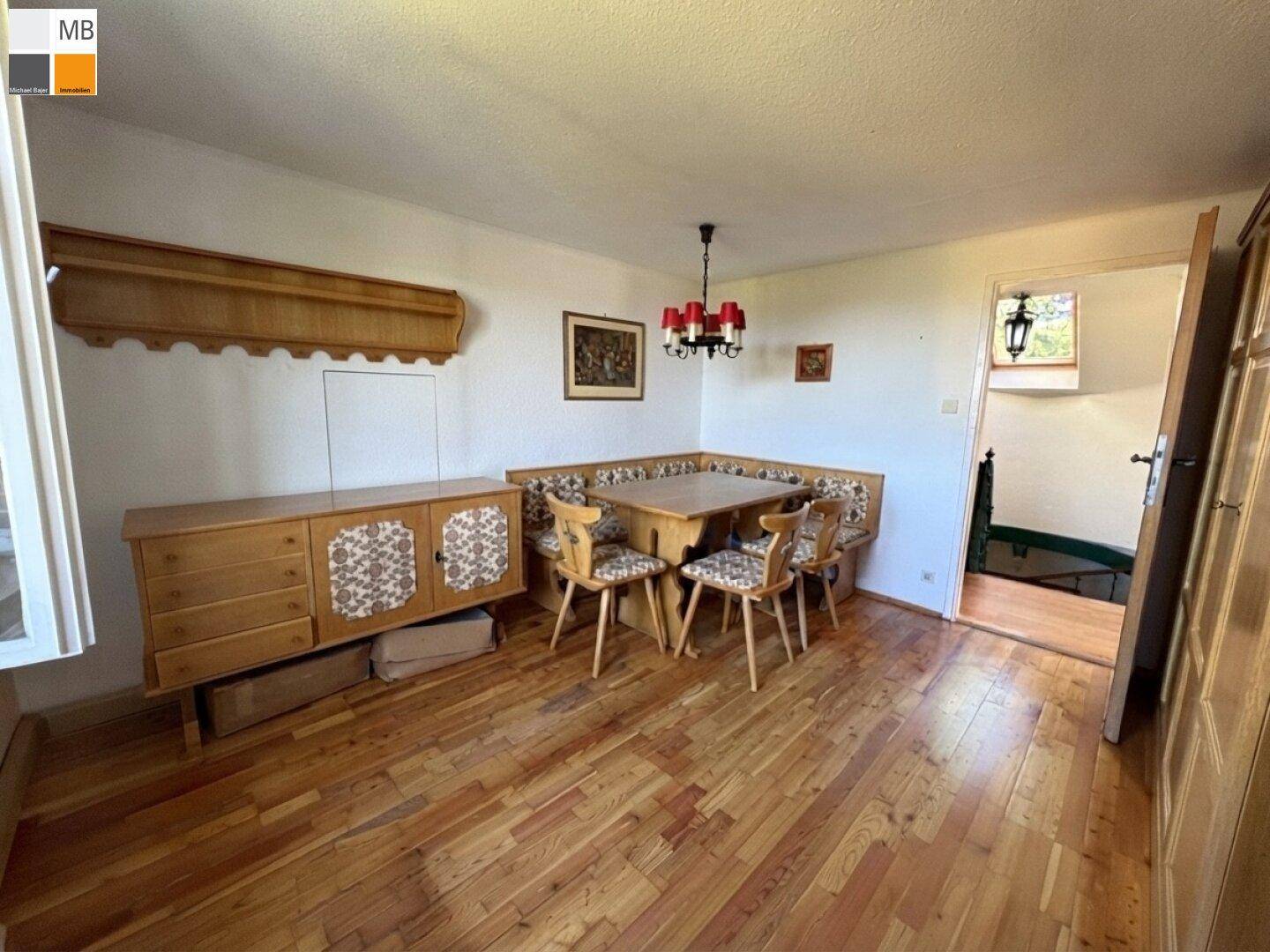 Gemütlicher Essbereich mit traditionellen Holzmöbeln und Dielenboden, ideal für Familienmahlzeiten.