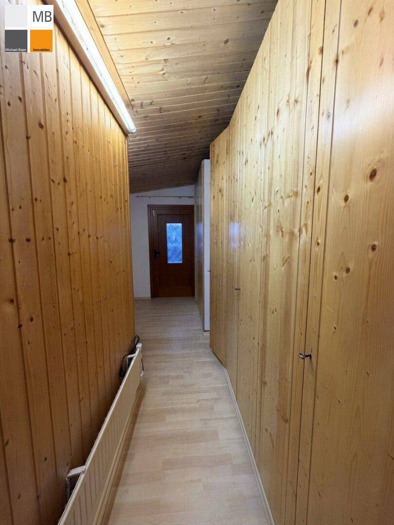 Schmaler Flur mit Holzvertäfelung und integrierten Schränken, bietet praktischen Stauraum.